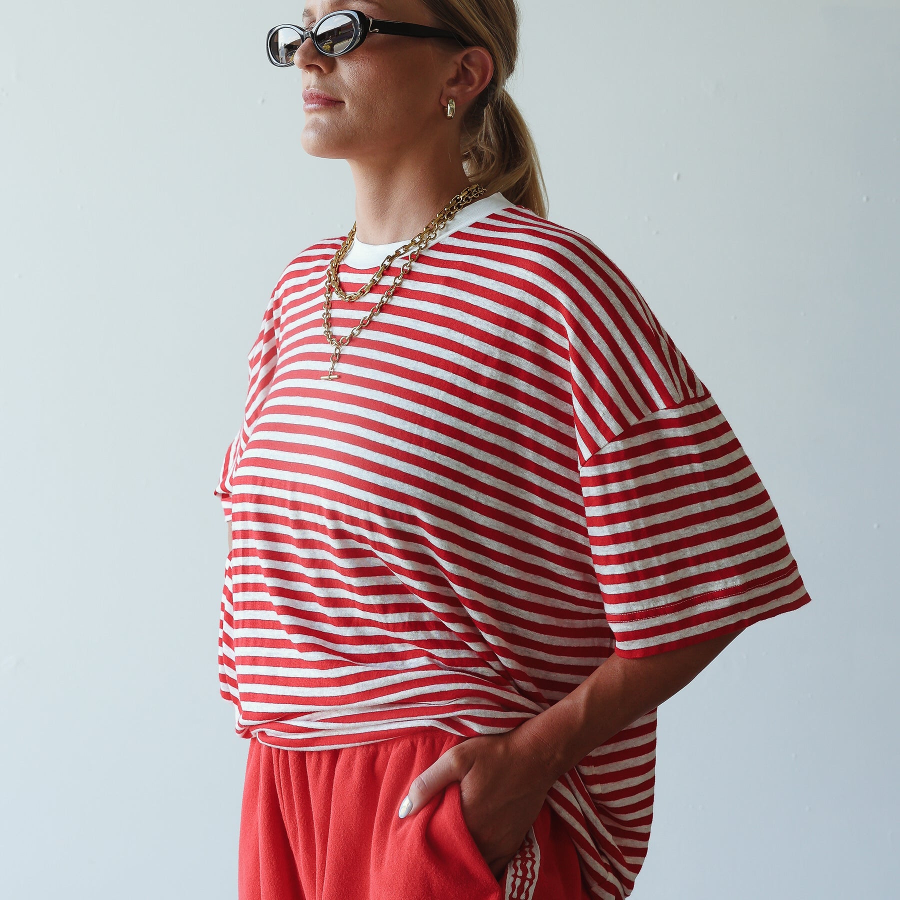 model wearing short red terry shorts by By Billie