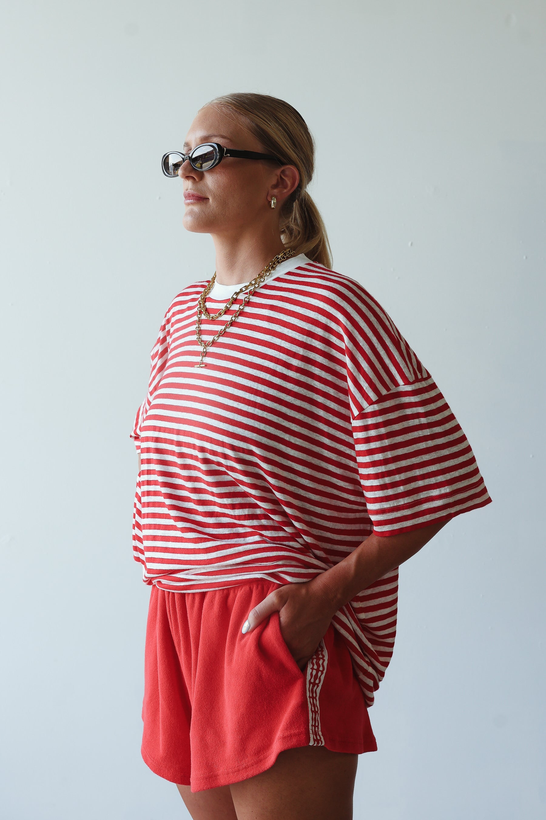 model wearing short red terry shorts by By Billie