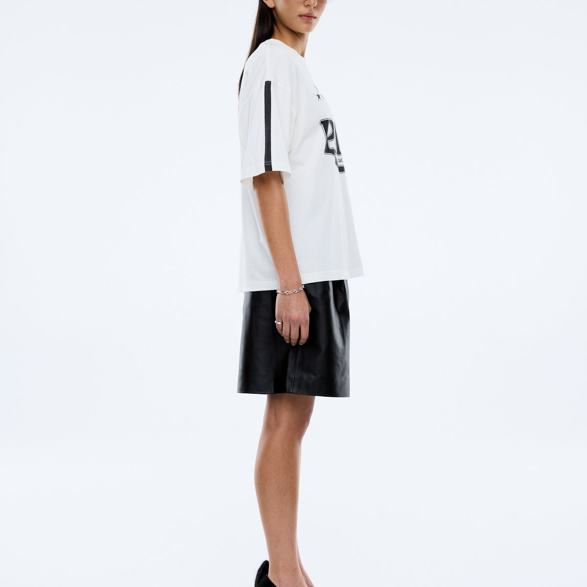 side view of Ena Pelly Racing Pelly Swoop vintage white graphic t-shirt displaying oversized fit and crew neckline