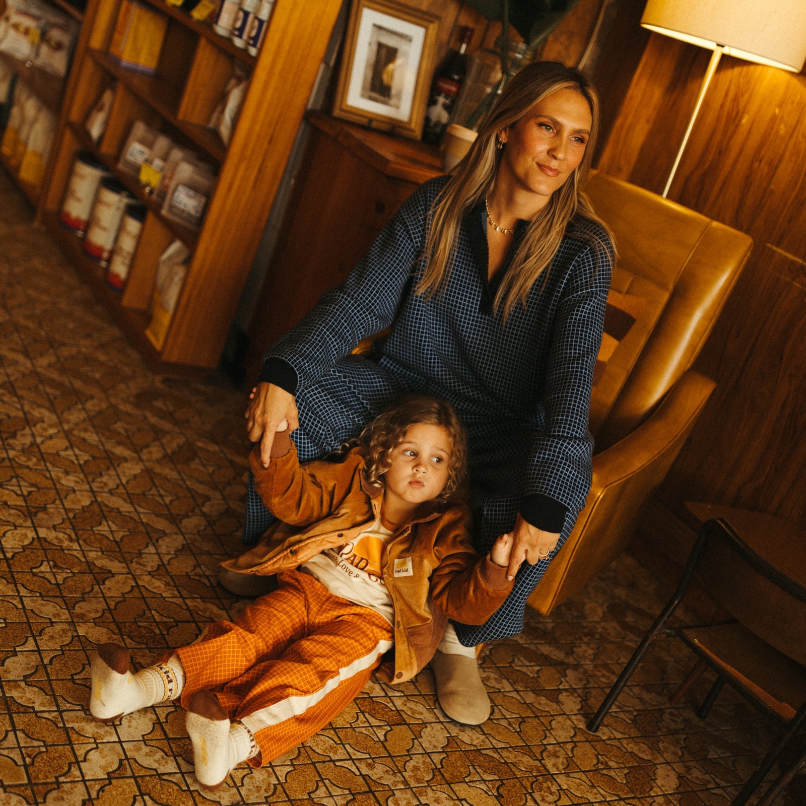 Close-up of smiling child in Rad Kid organic pajama top lying on white bedding