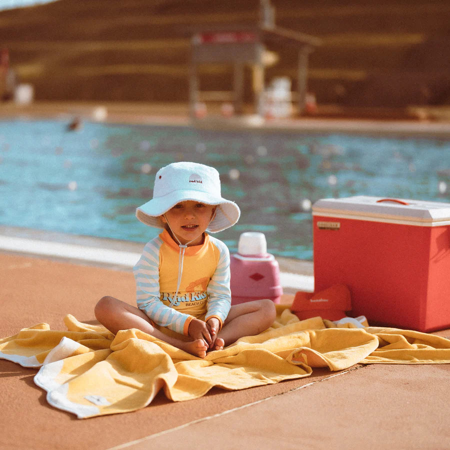 Child sitting next to a pool wear Rad Kid Terry Hat Reef By Banabae