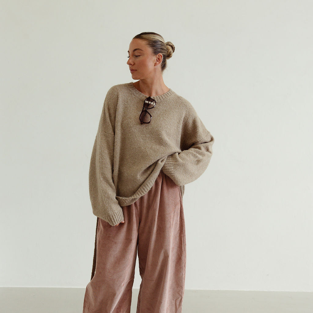 Ren Cord Pant musk pink styled casually with oversized sweater showing relaxed corduroy silhouette