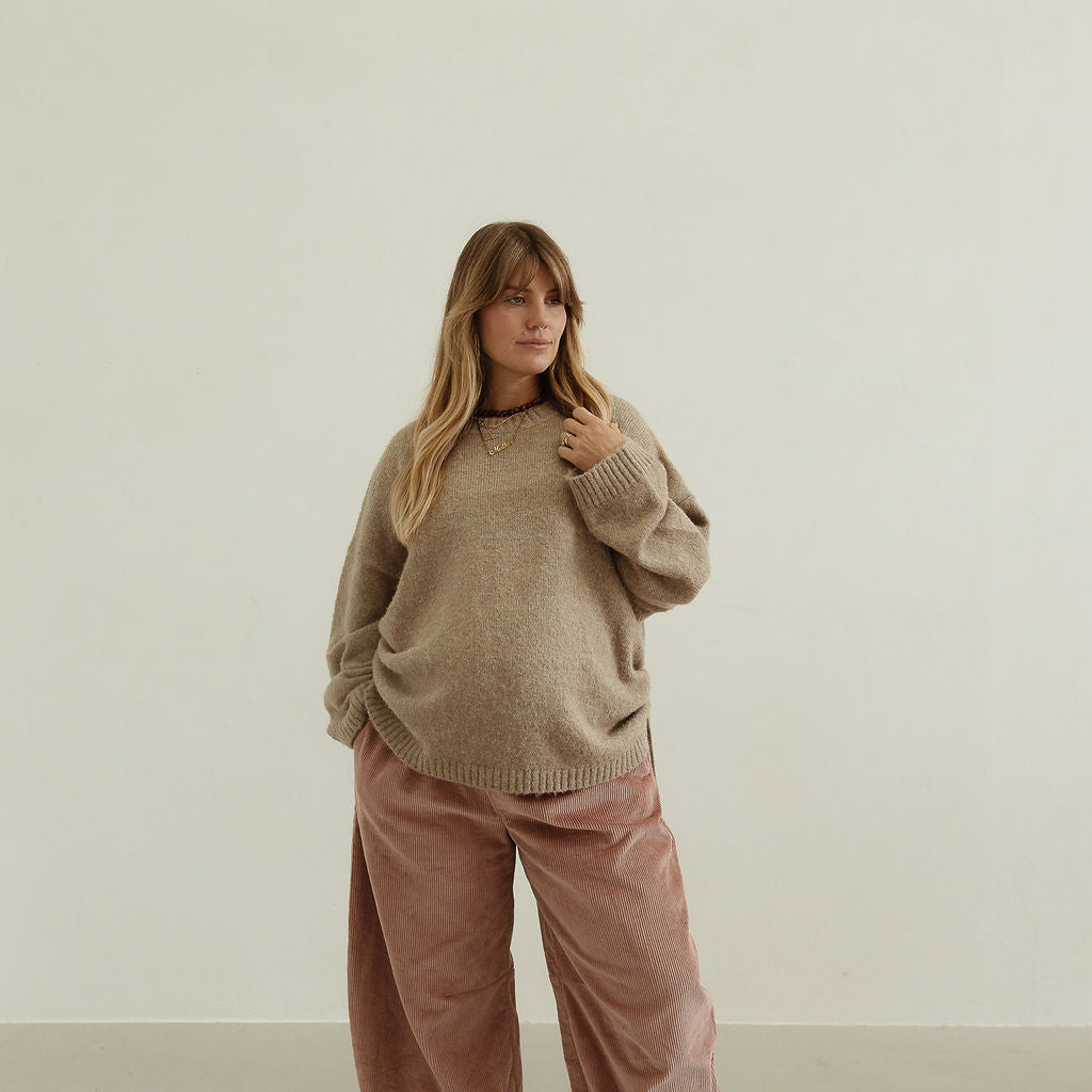 Close-up styling shot of Ren Cord Pant in musk pink showing oversized comfortable fit
