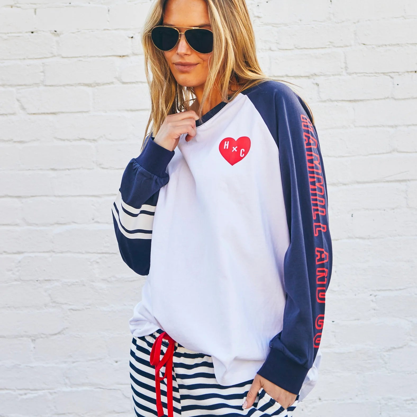 model wearing Hammill & Co long sleeved tshirt with navy sleeves and red heart detail