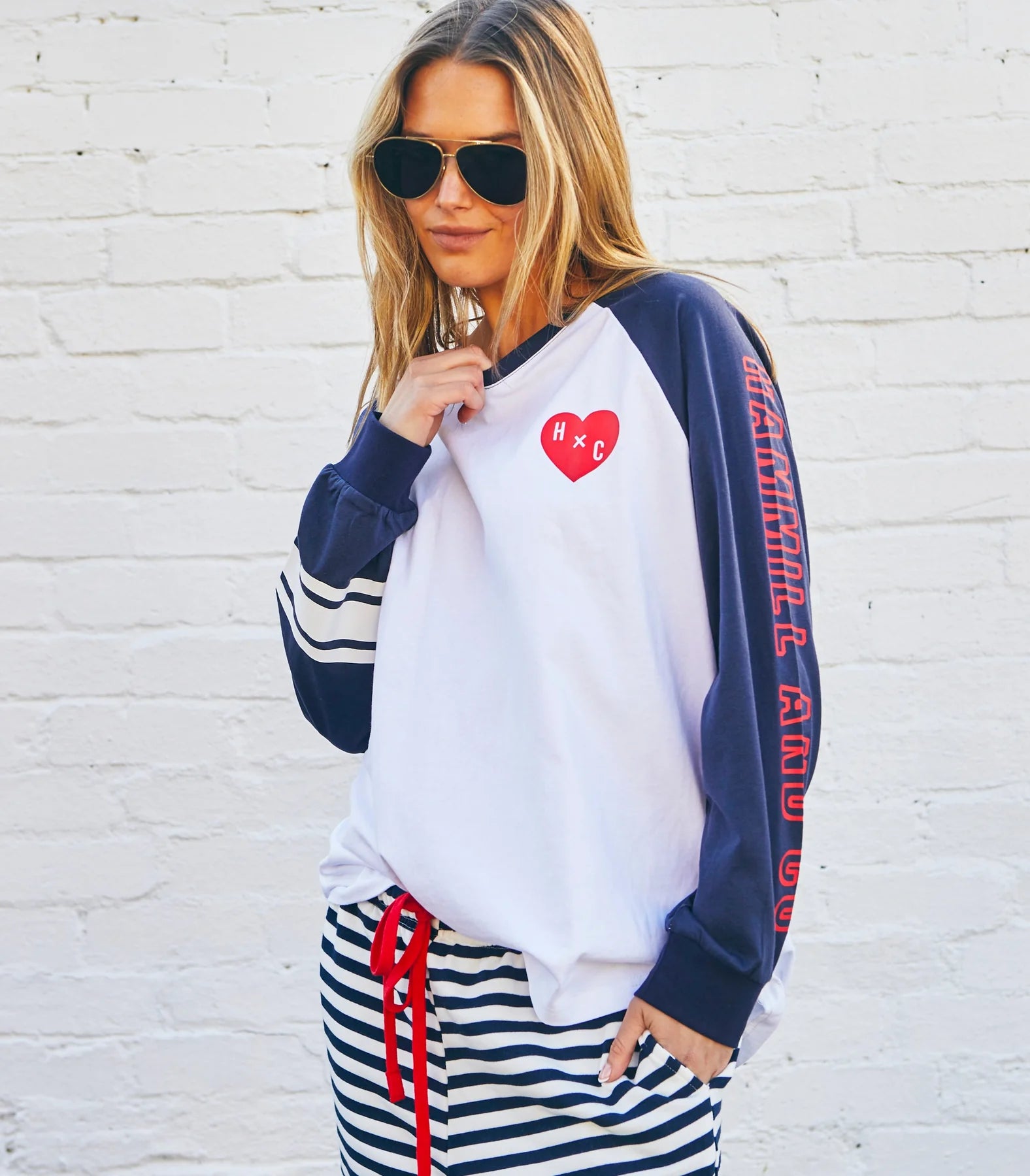 model wearing Hammill & Co long sleeved tshirt with navy sleeves and red heart detail