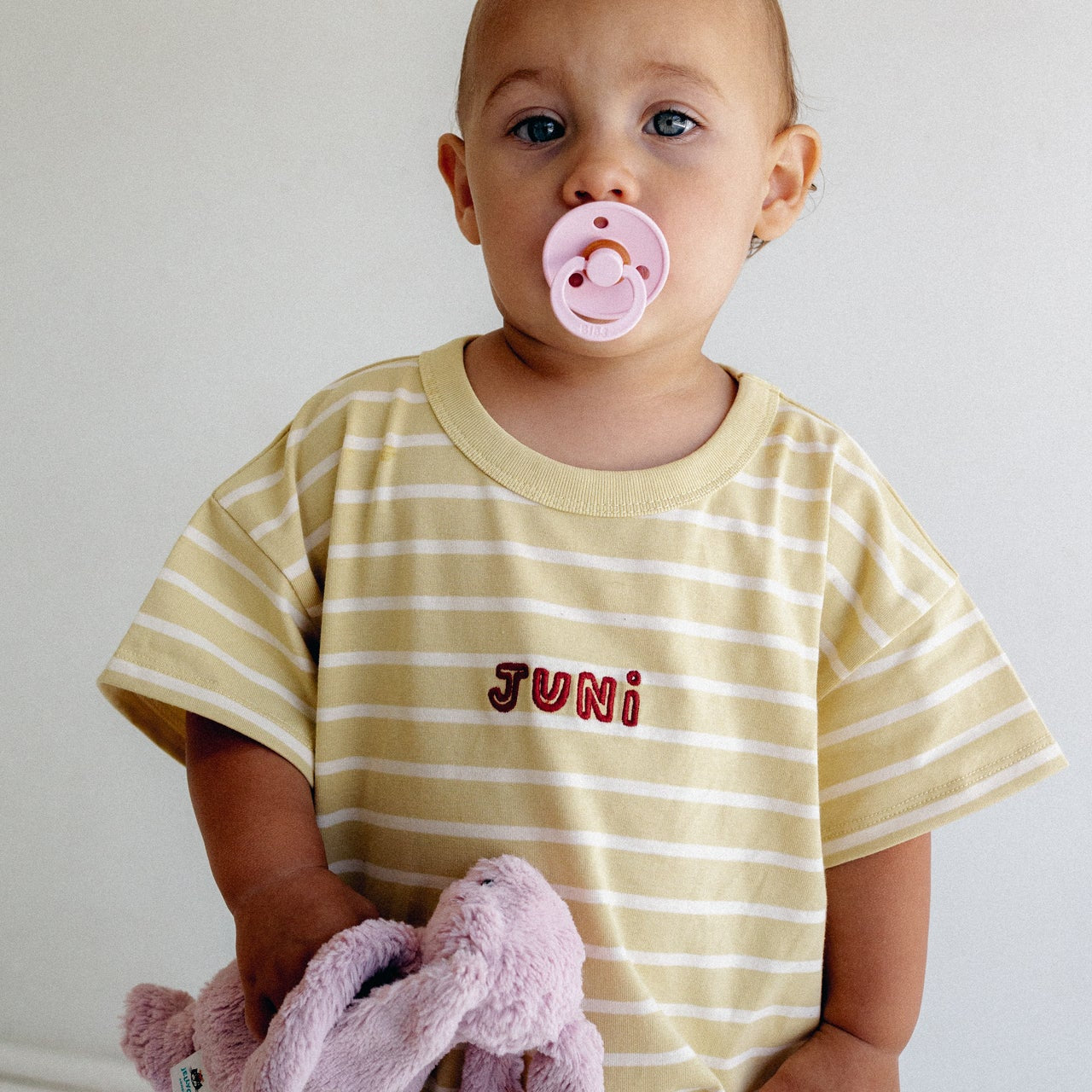 toddler wearing yellow and white striped romper by Juni