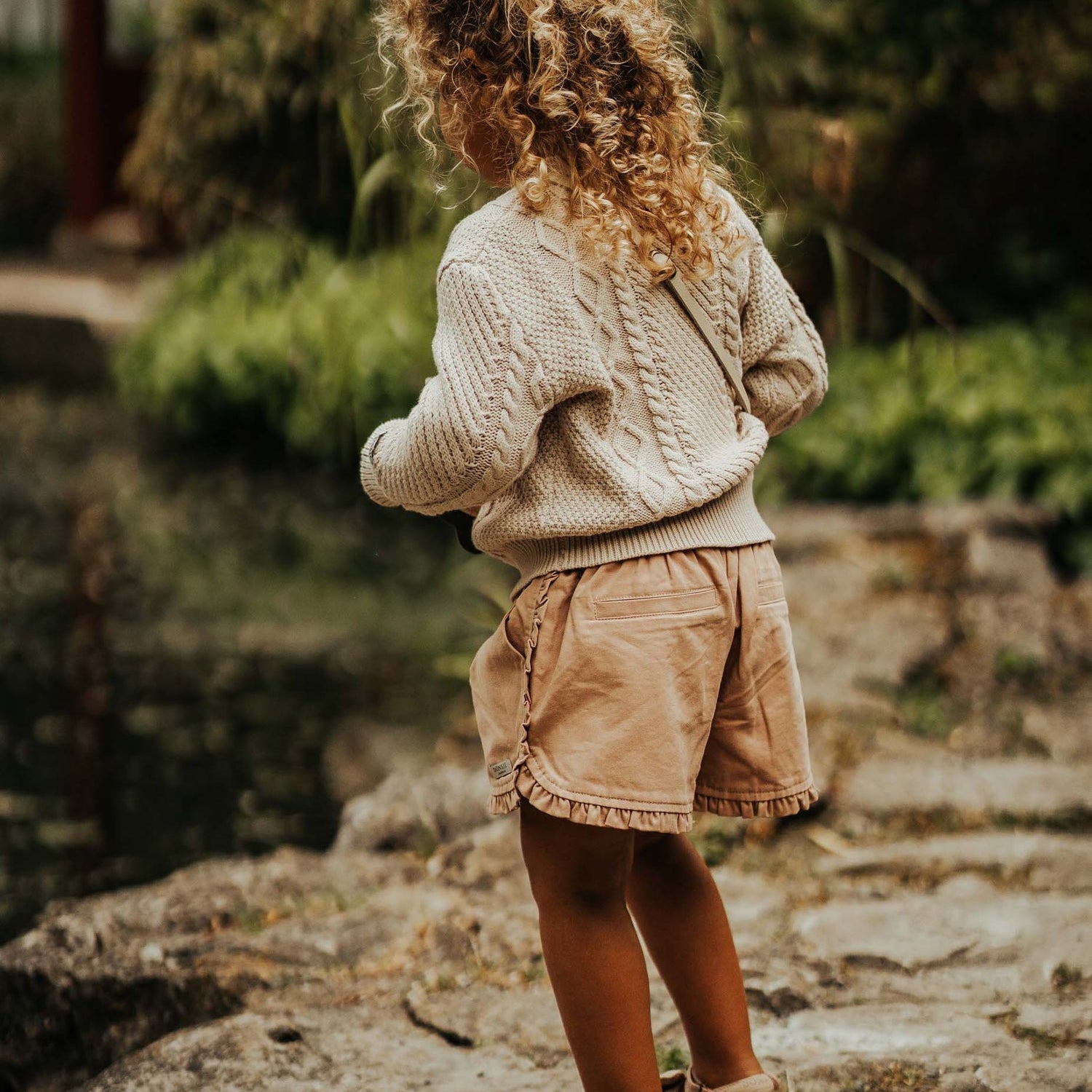 Young girl wearing the Romaine Sweater - Soft Sand | Donsje