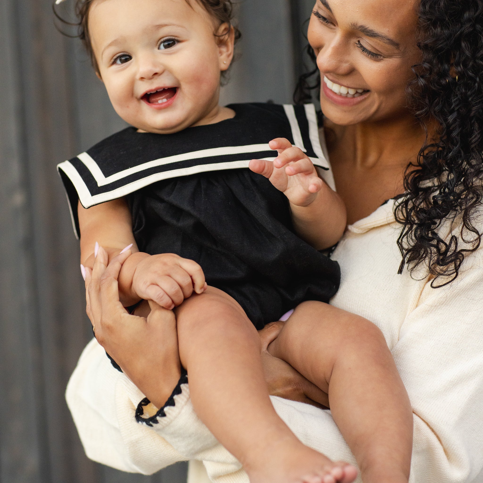 Front view of a baby girl in the Sailor Romper Black | Rylee + Cru