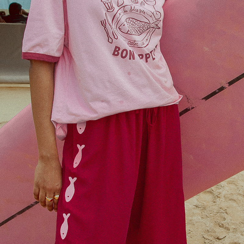 Burgundy and pink womens pants with emroidered fish motif down sides