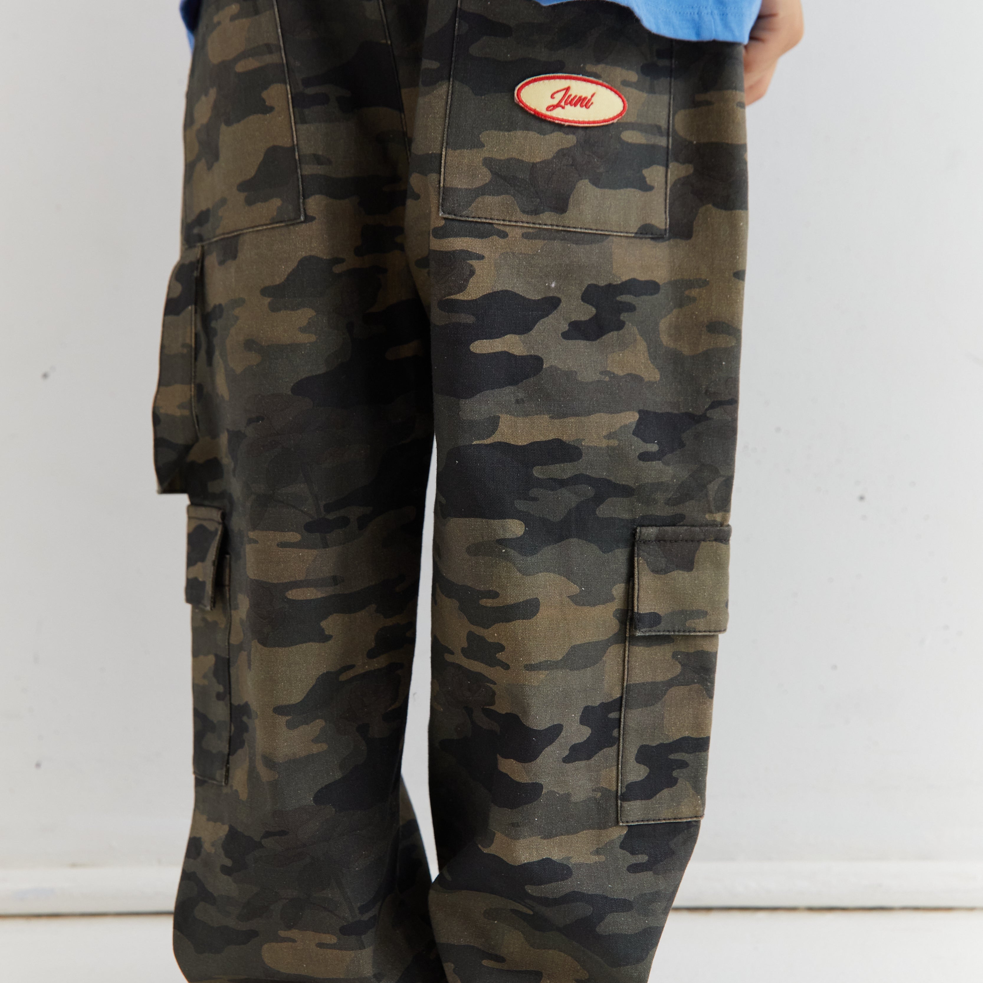 Close-up of Scottie Pants camo cargo pockets with Juni brand label detail