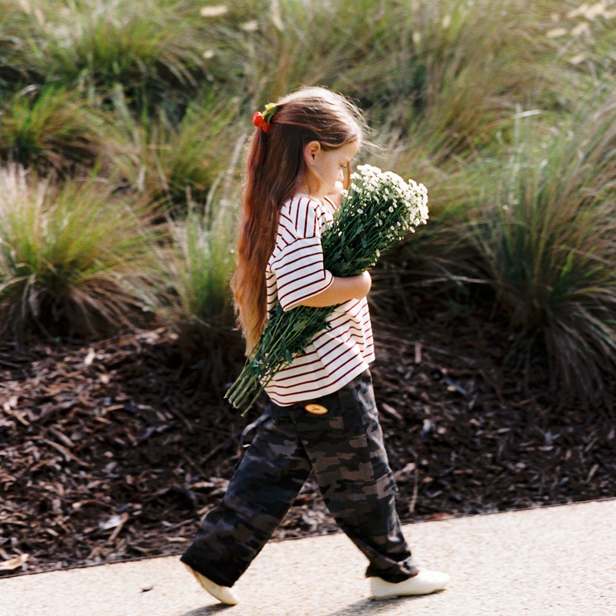 Child walking in camo Scottie Pants showing movement and relaxed fit outdoors