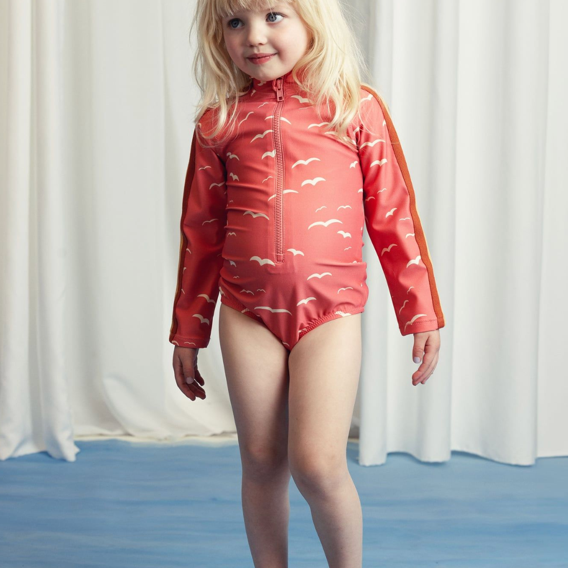 Front view of girl wearing the Seagull Long sleeve Swimsuit - Pink | Mini Rodini