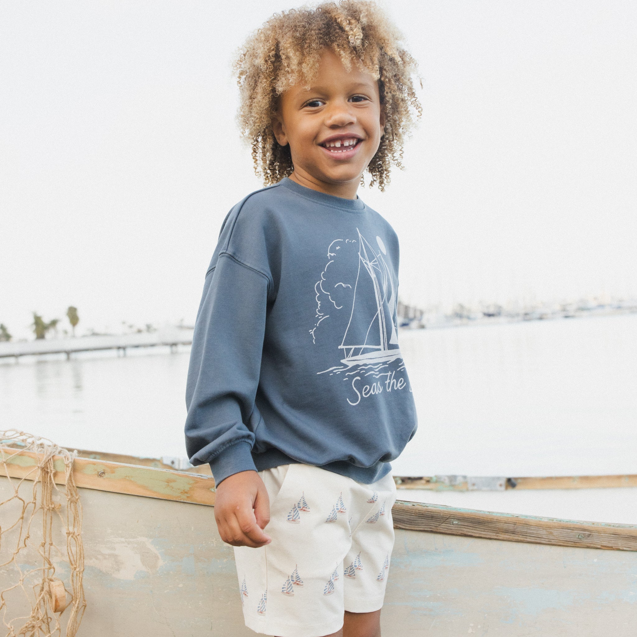 Side view of young boy in the Seas The Day Sweatshirt | Rylee + Cru