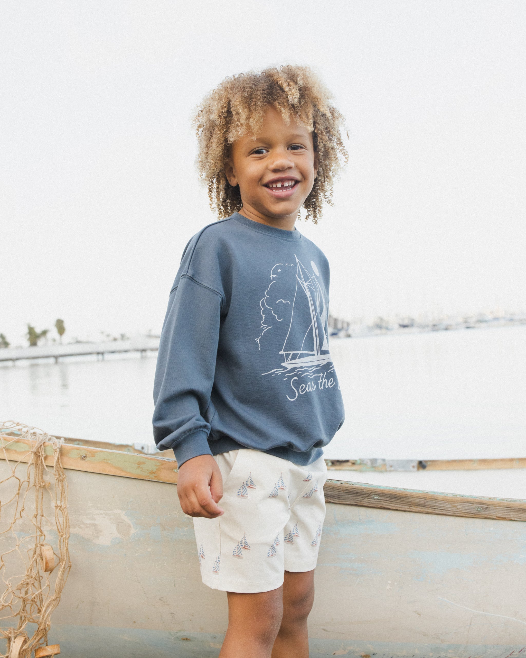 Side view of young boy in the Seas The Day Sweatshirt | Rylee + Cru