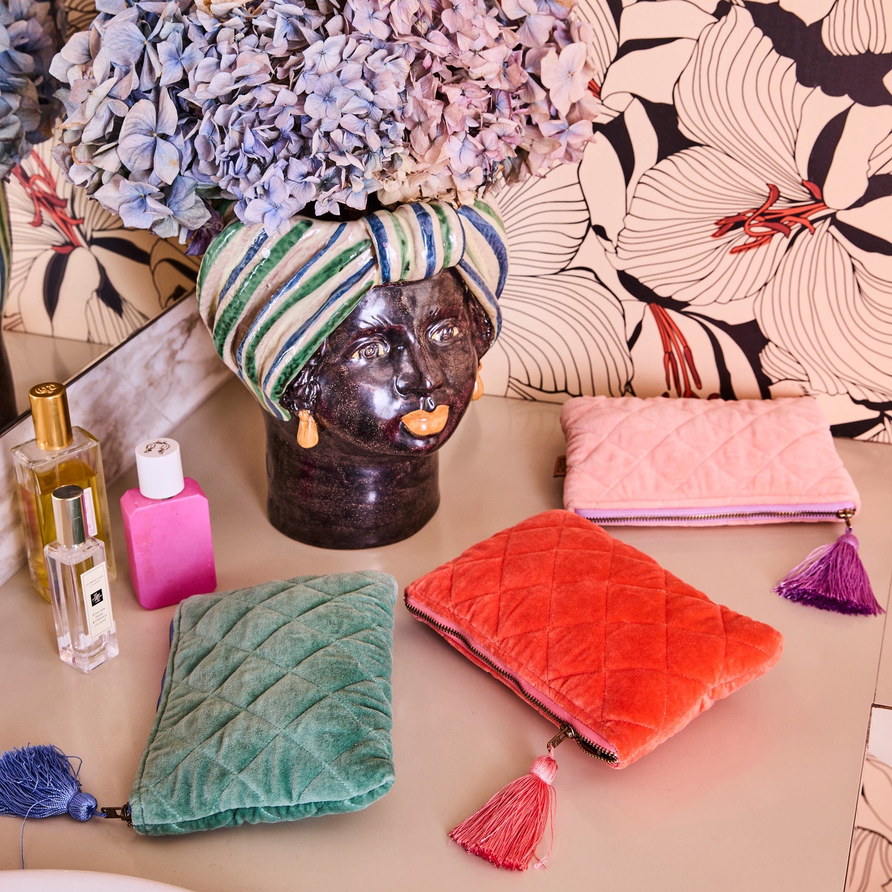 Sherbet Velvet Cosmetics Purse by Kip & Co in coral orange quilted velvet with tassel zipper pull styled with makeup