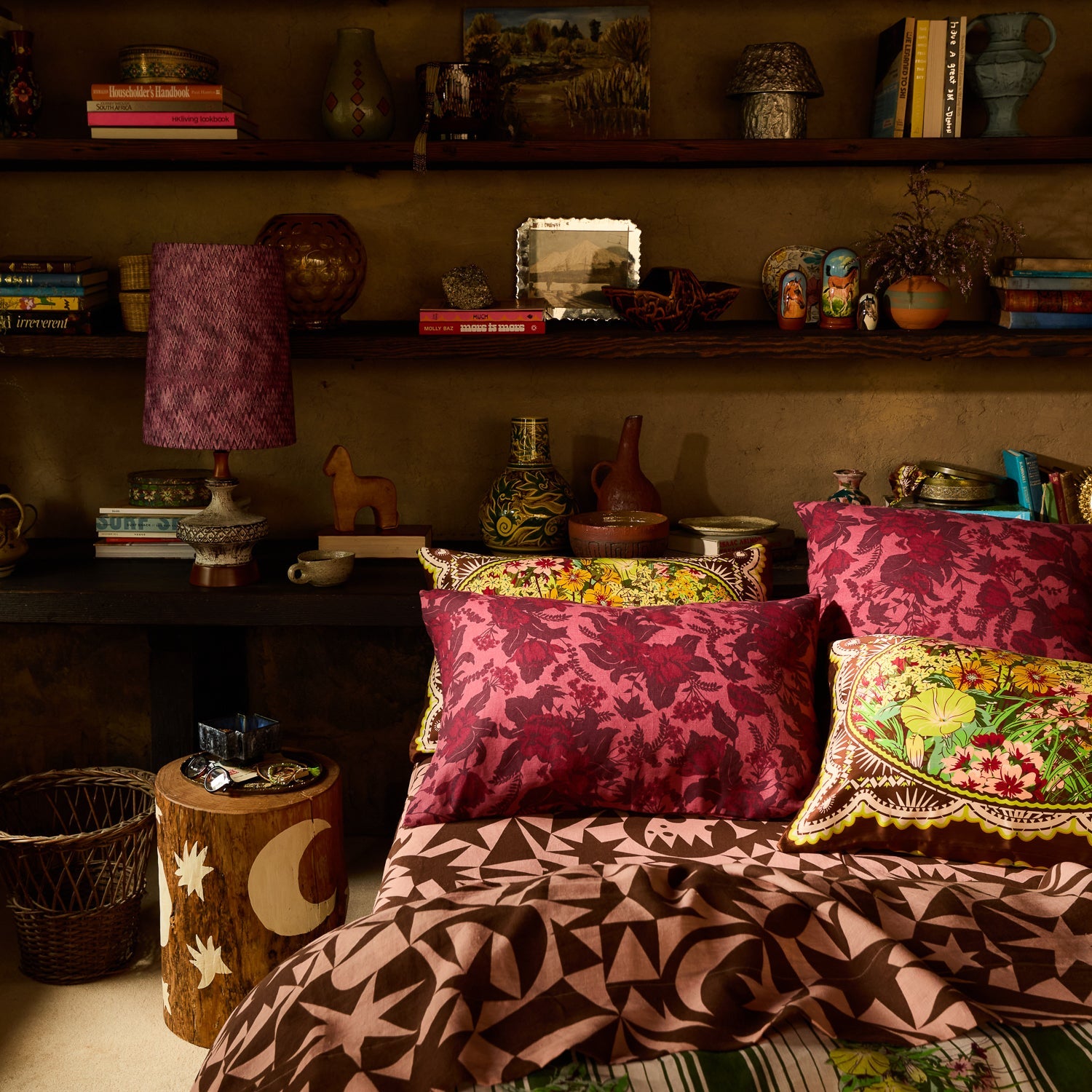 Deep pink botanical floral linen pillowcases layered on a boho-styled bed in an eclectic bedroom