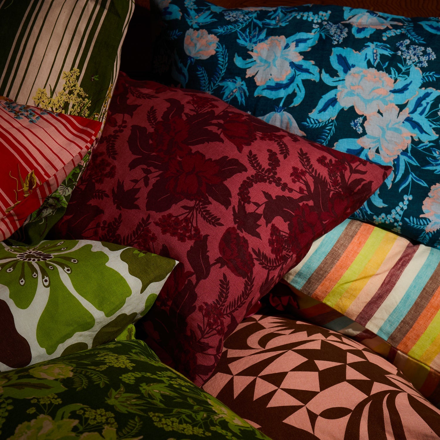 Crimson botanical floral linen pillowcase among a colourful mix of patterned pillowcases