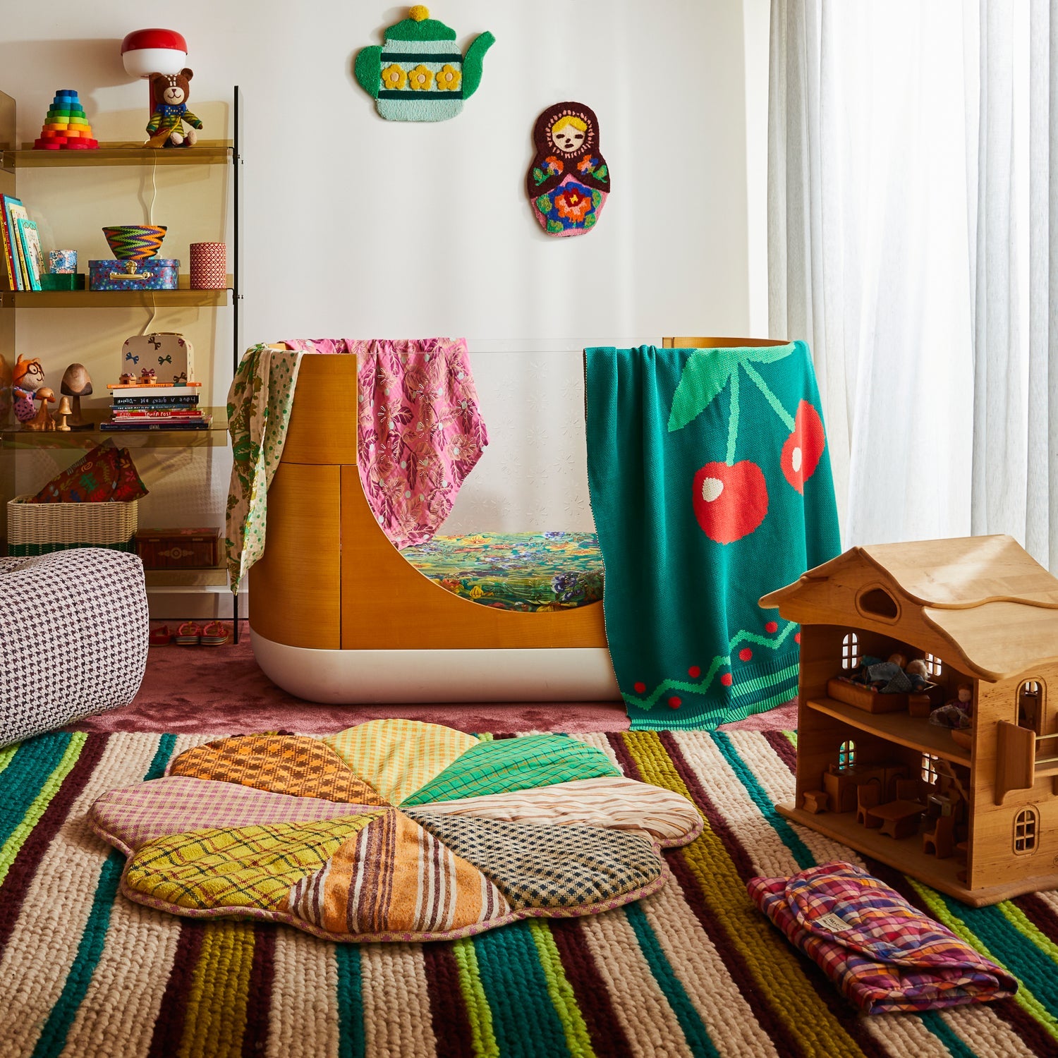 Pink tropical print baby wrap displayed in colorful children's playroom with toys and dollhouse