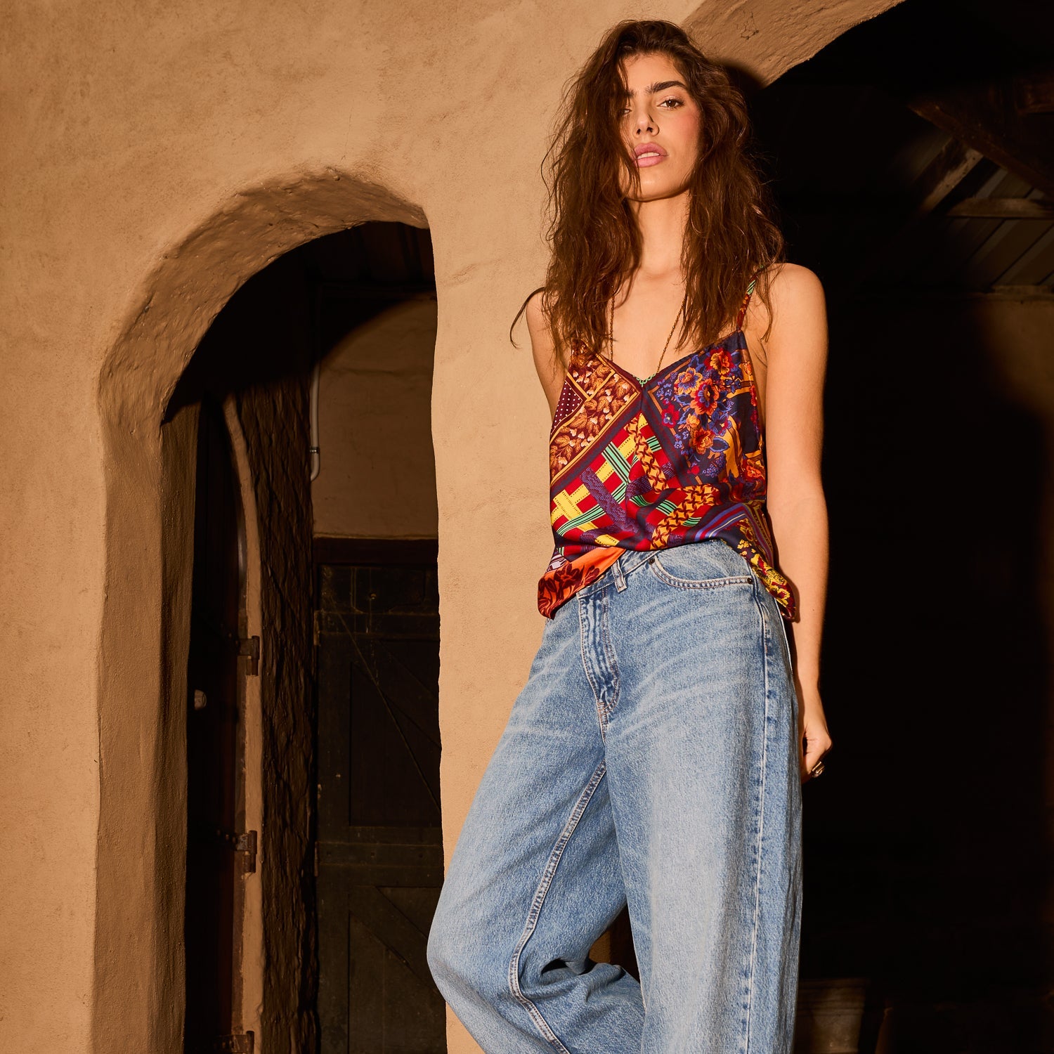 Multicolor patchwork print cami top with V-neckline and thin straps, tucked into wide-leg jeans