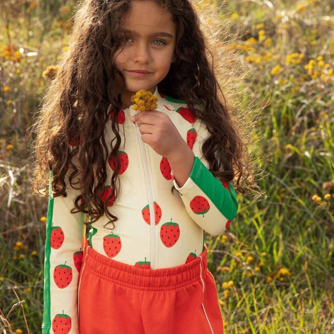 Kid wearing the Strawberries aop ls uv swimsuit - Off-white| Mini Rodini