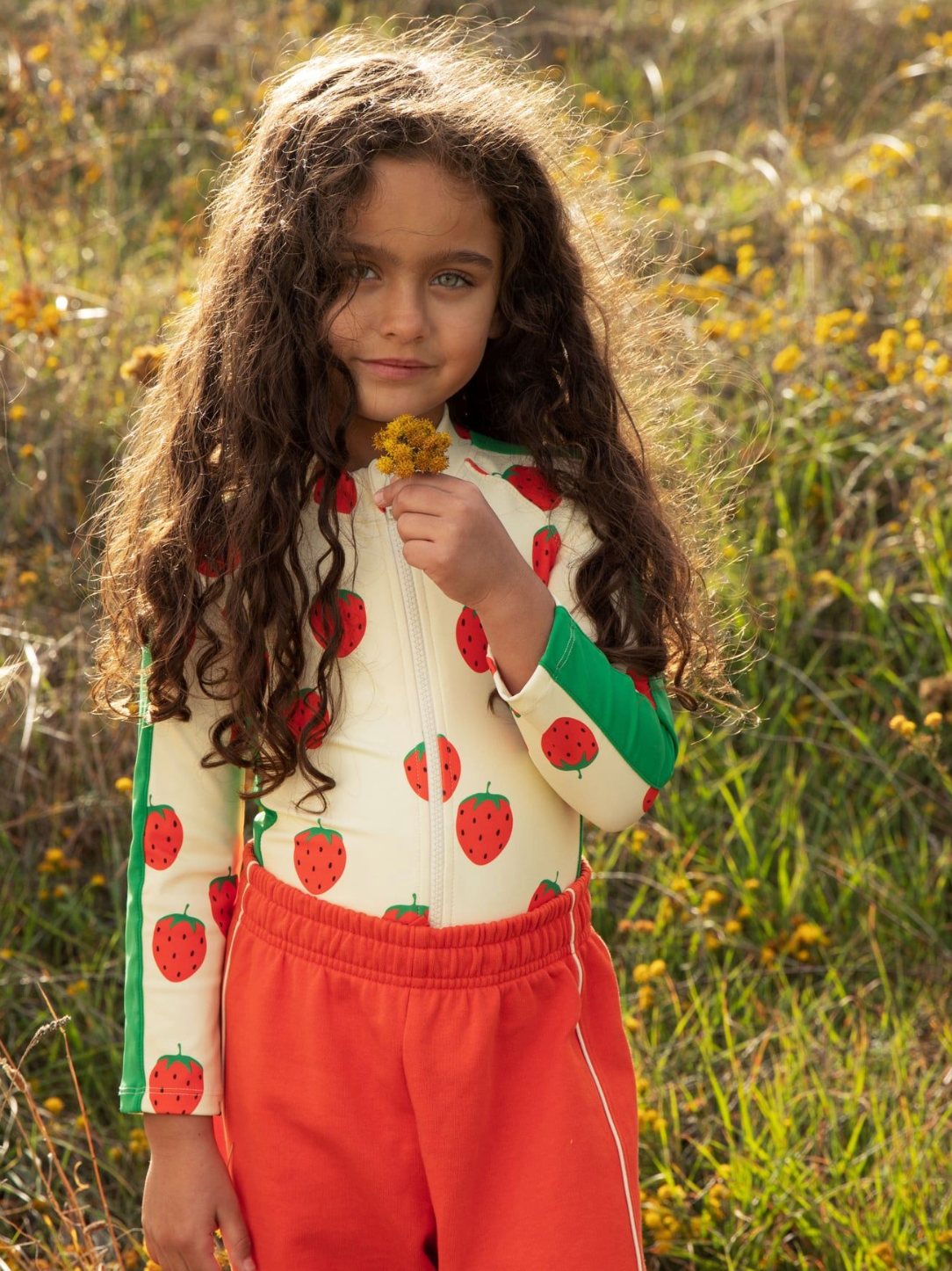 Kid wearing the Strawberries aop ls uv swimsuit - Off-white| Mini Rodini
