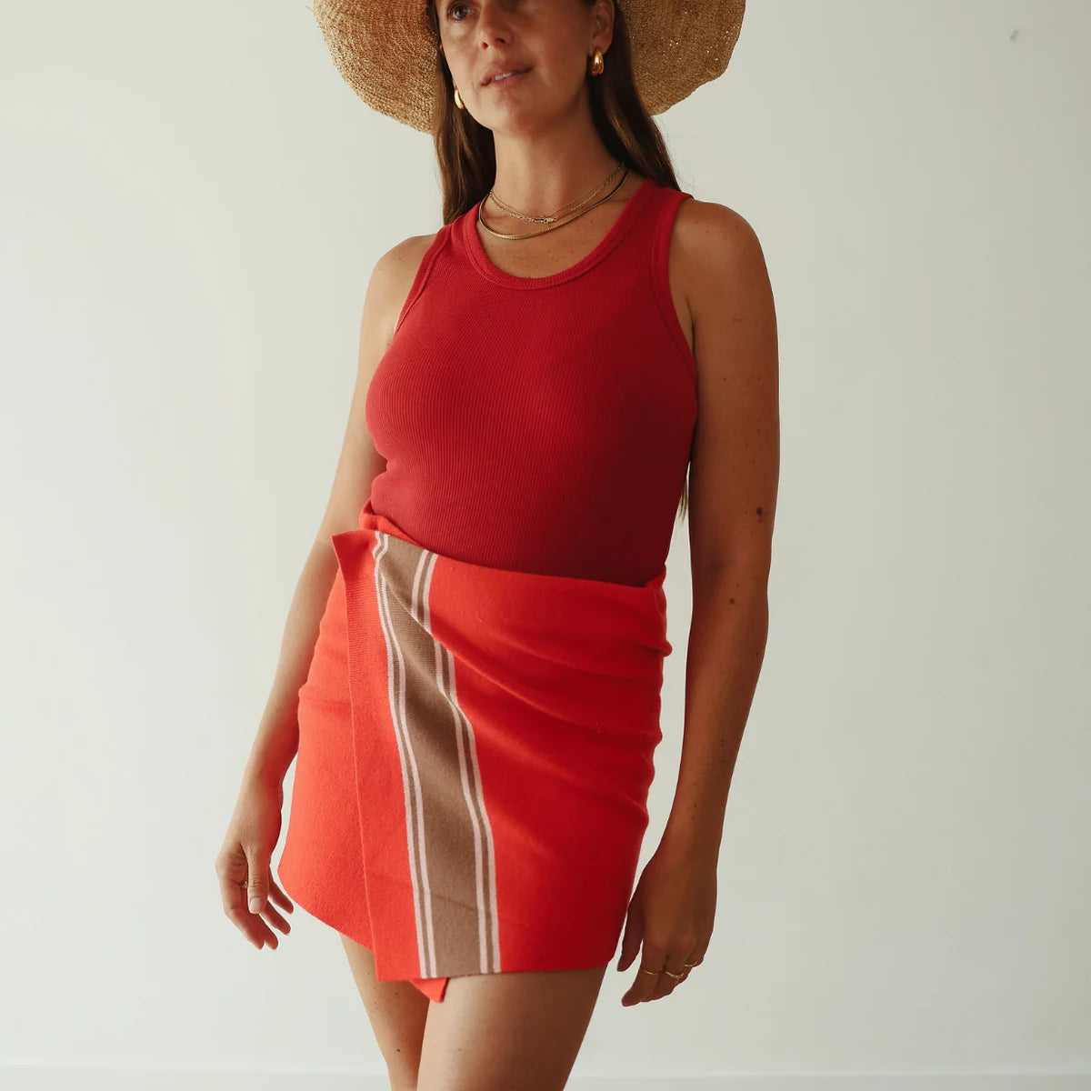 model wearing Stripe Knit Skirt – Red by By Billie. Red woven skirt with brown stripe