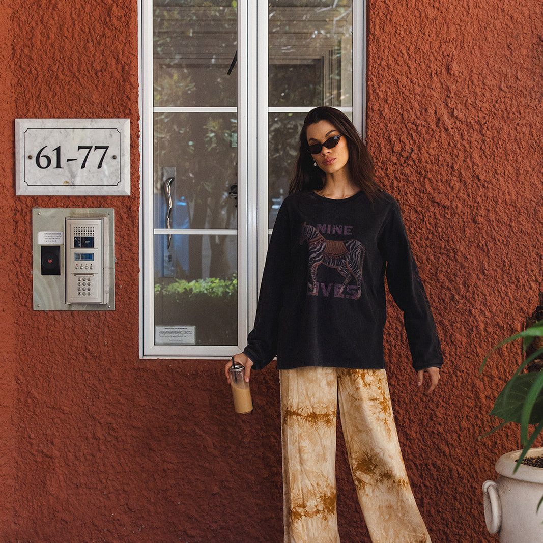Side profile view of Sunday Pants highlighting crochet lace trim and tie-dye pattern