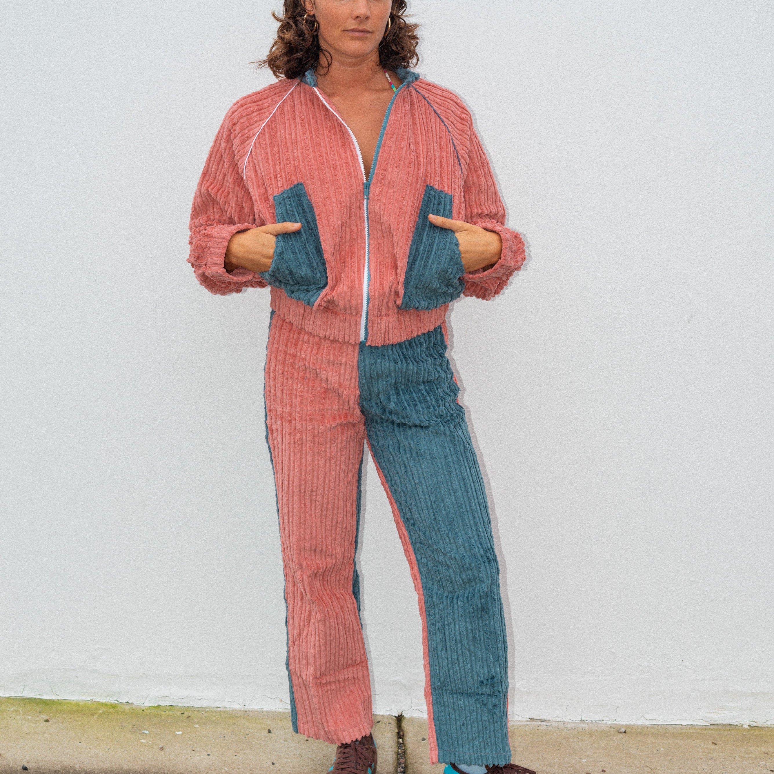 Full length front view of pink blue two tone corduroy bomber jacket showing zip closure and relaxed fit