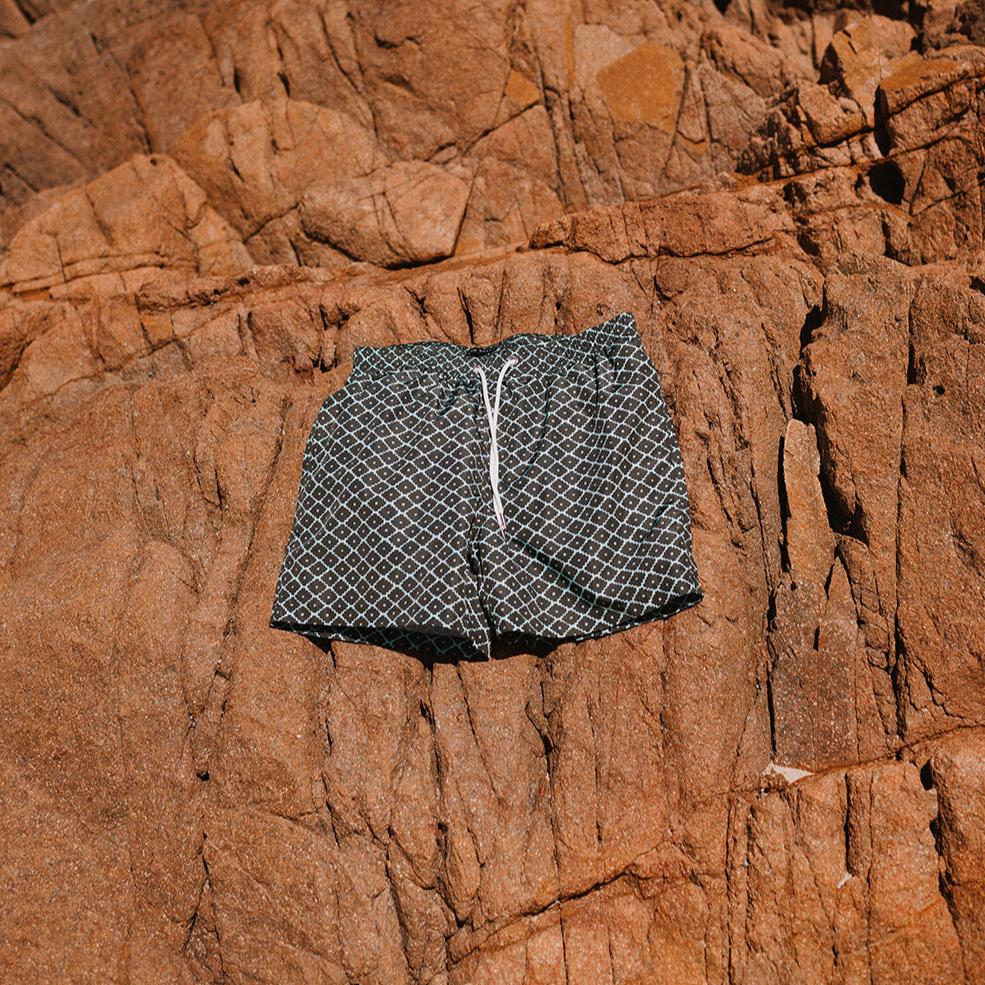 Flat lay of evergreen diamond swim shorts by Swim Shady