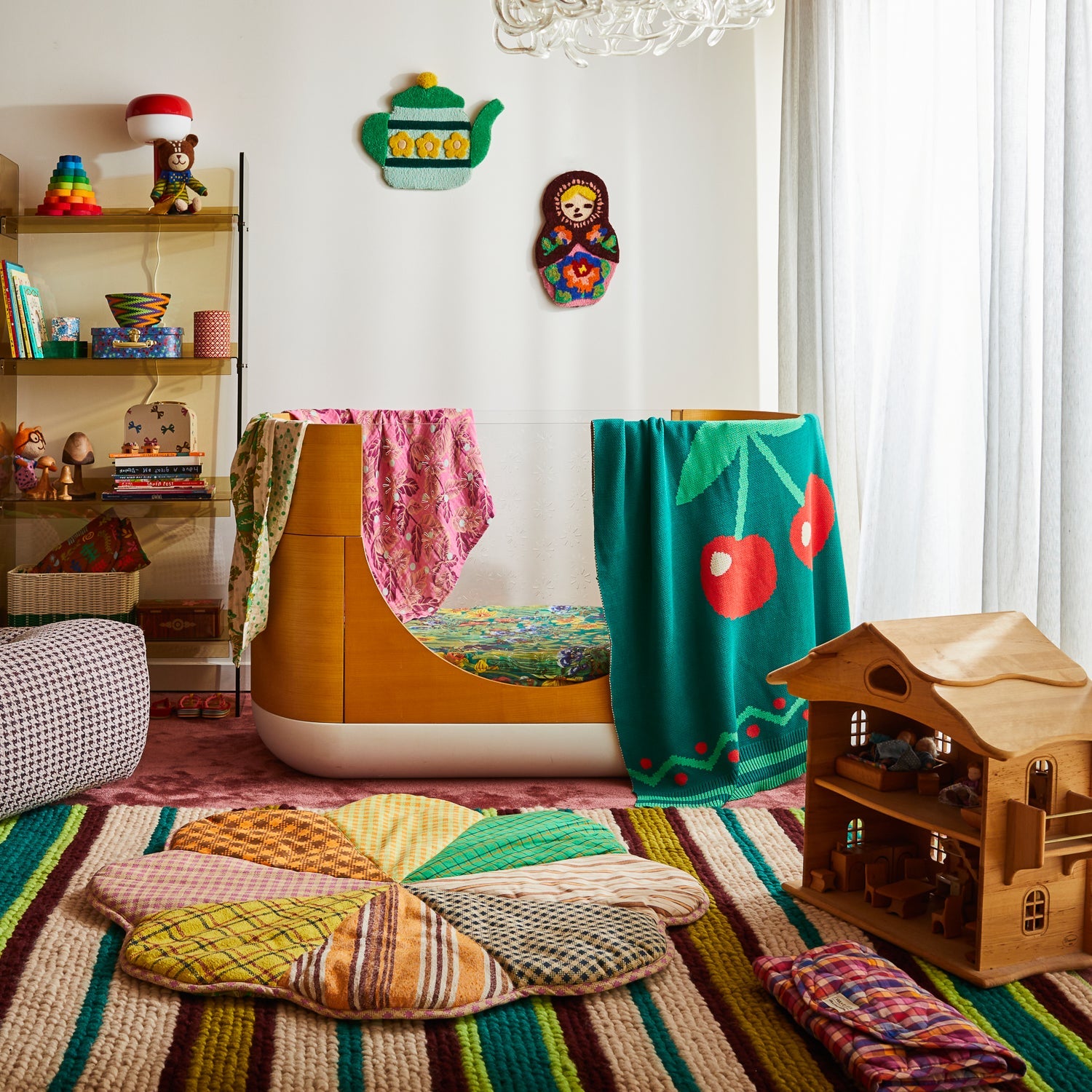 Green knit Tea Baby Blanket with cherry design draped over chair in bright children's bedroom