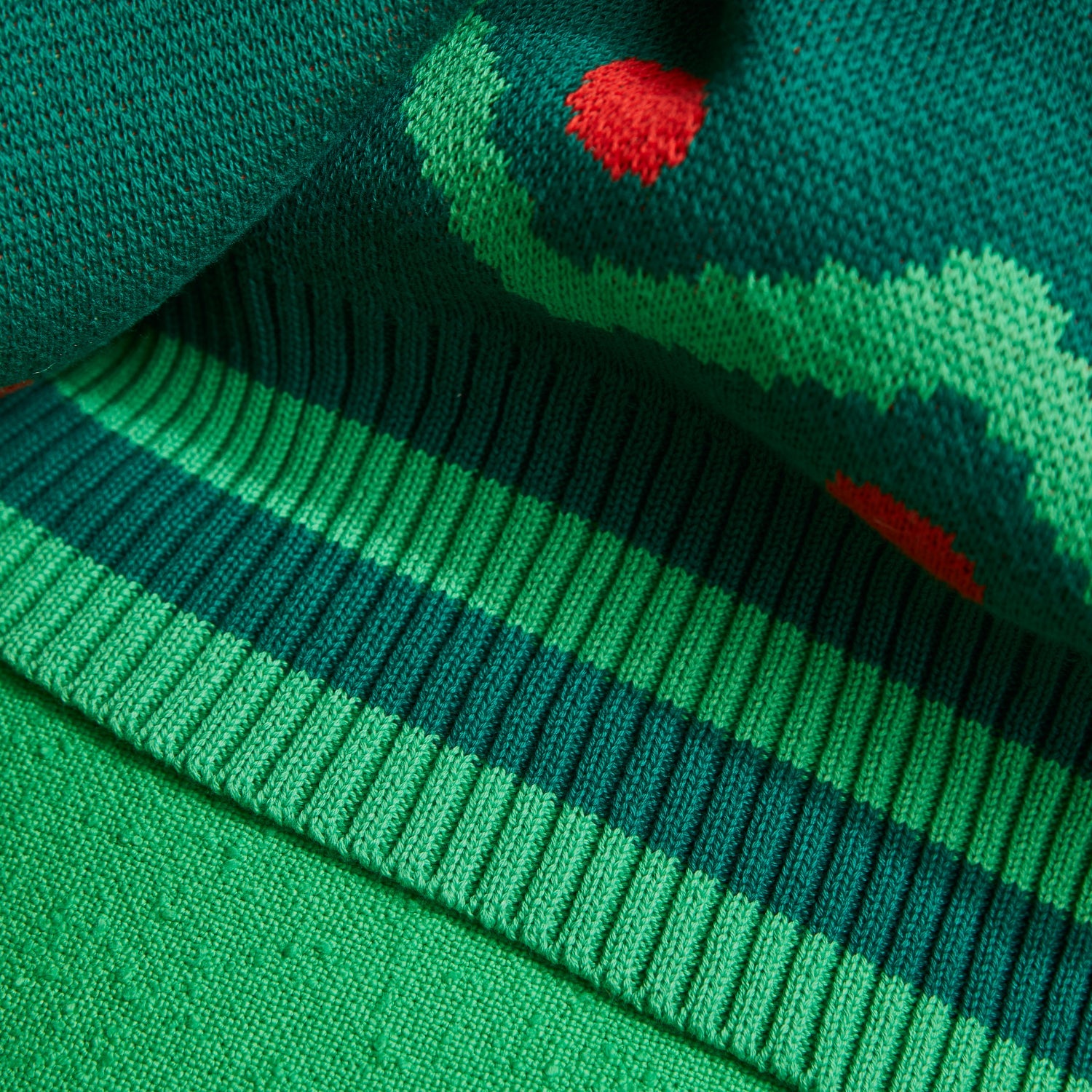Detail view of green ribbed border edge with red dots on Tea Baby Blanket
