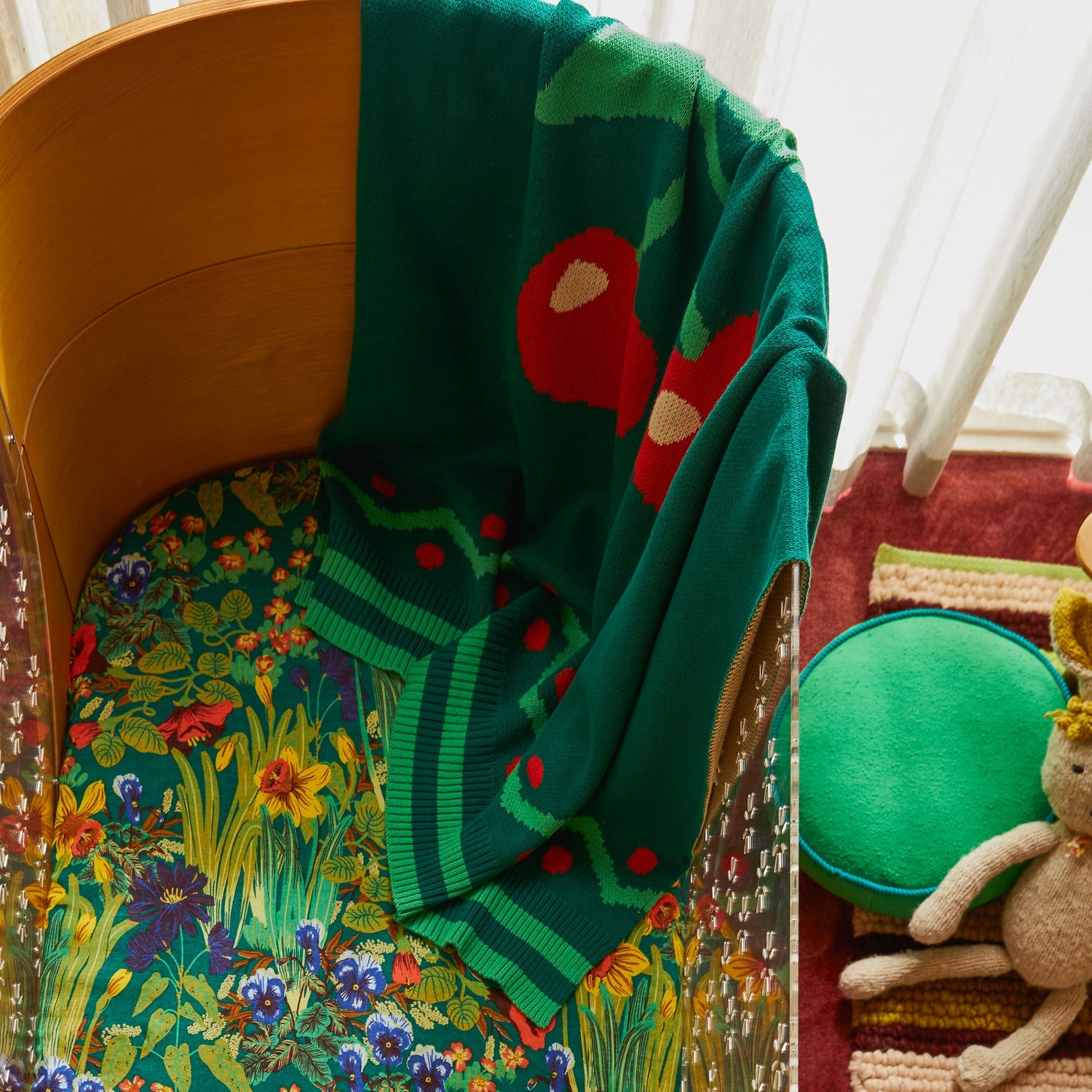 Tea Baby Blanket folded on chair showing cherry motif and zigzag border pattern