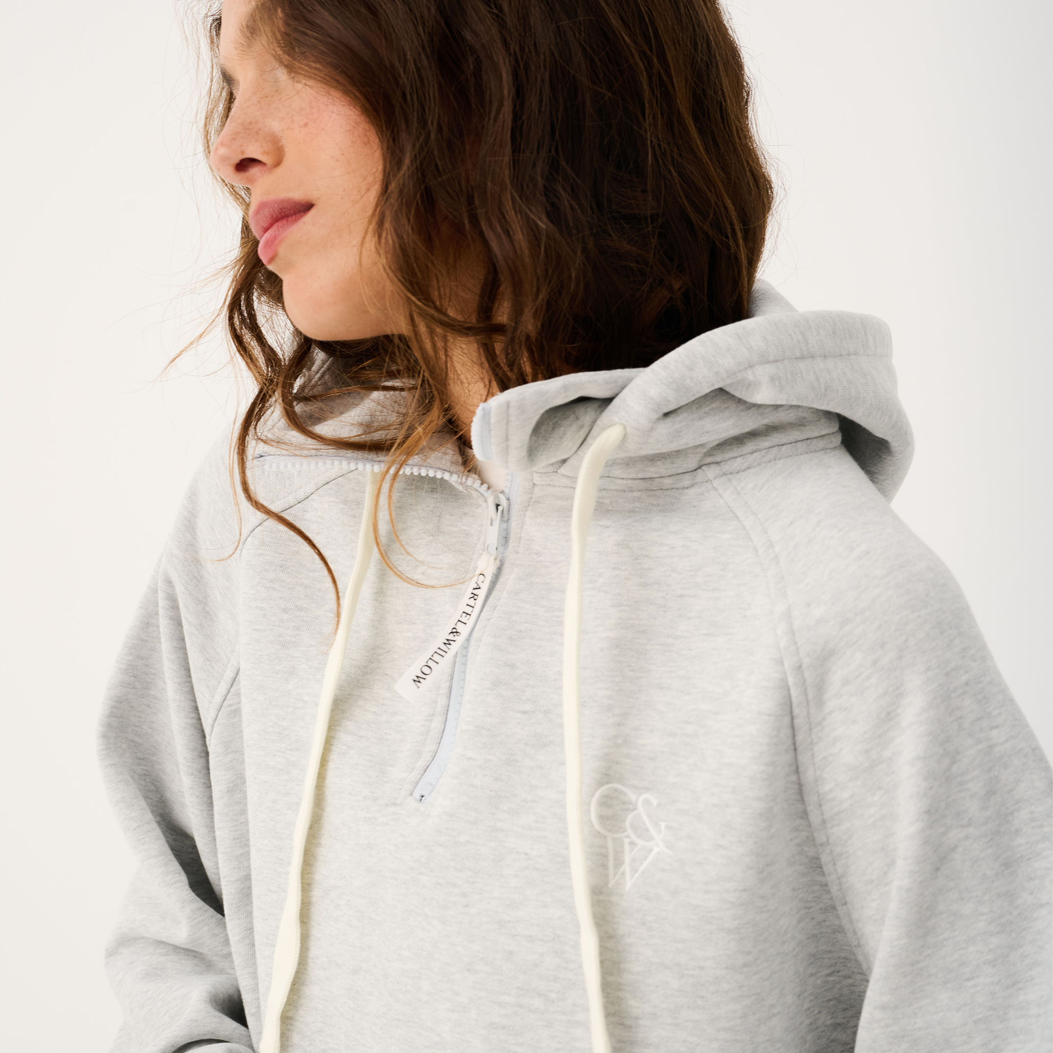 Side angle of grey marle Teagan Hoodie highlighting hood drawstrings and oversized silhouette