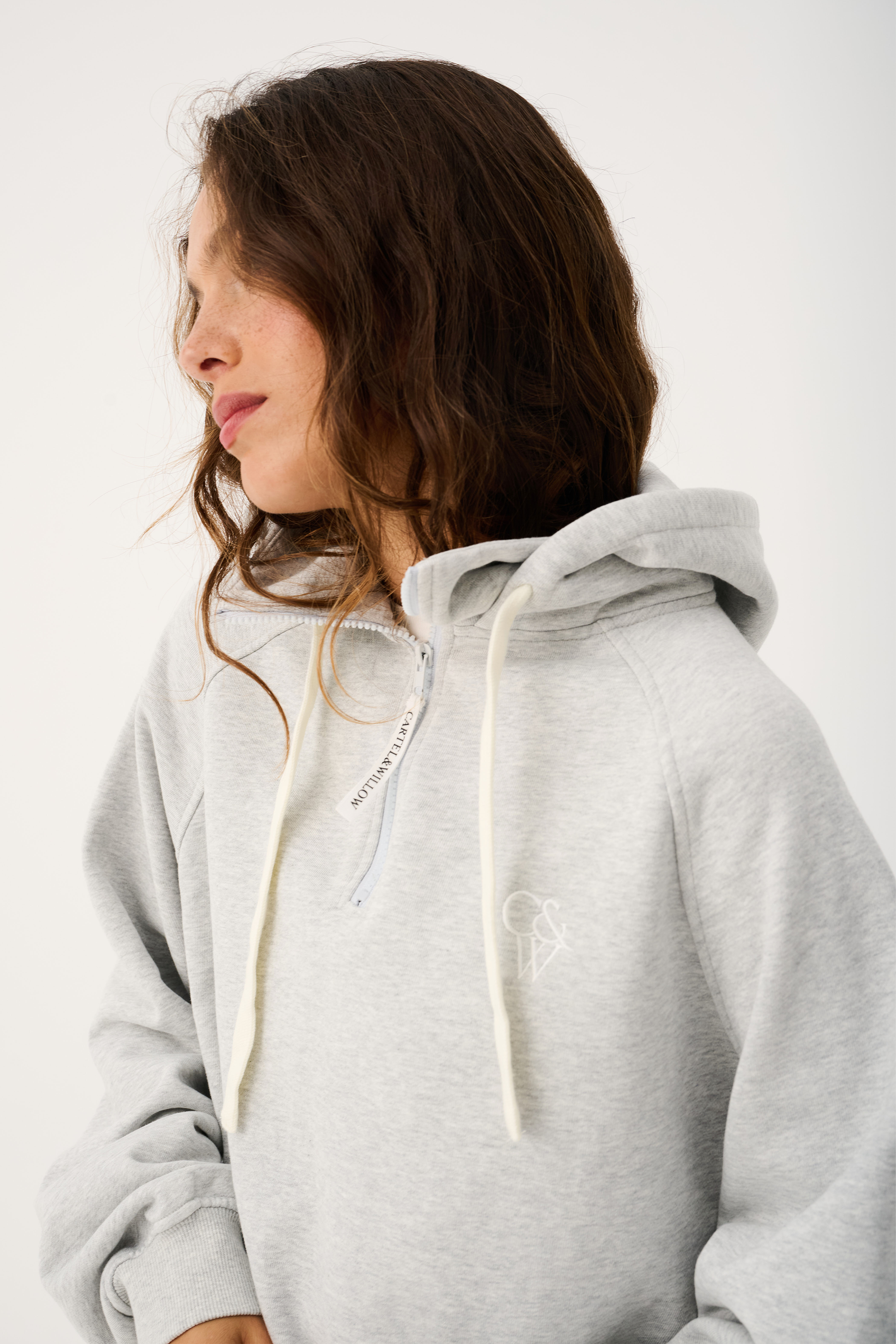 Side angle of grey marle Teagan Hoodie highlighting hood drawstrings and oversized silhouette