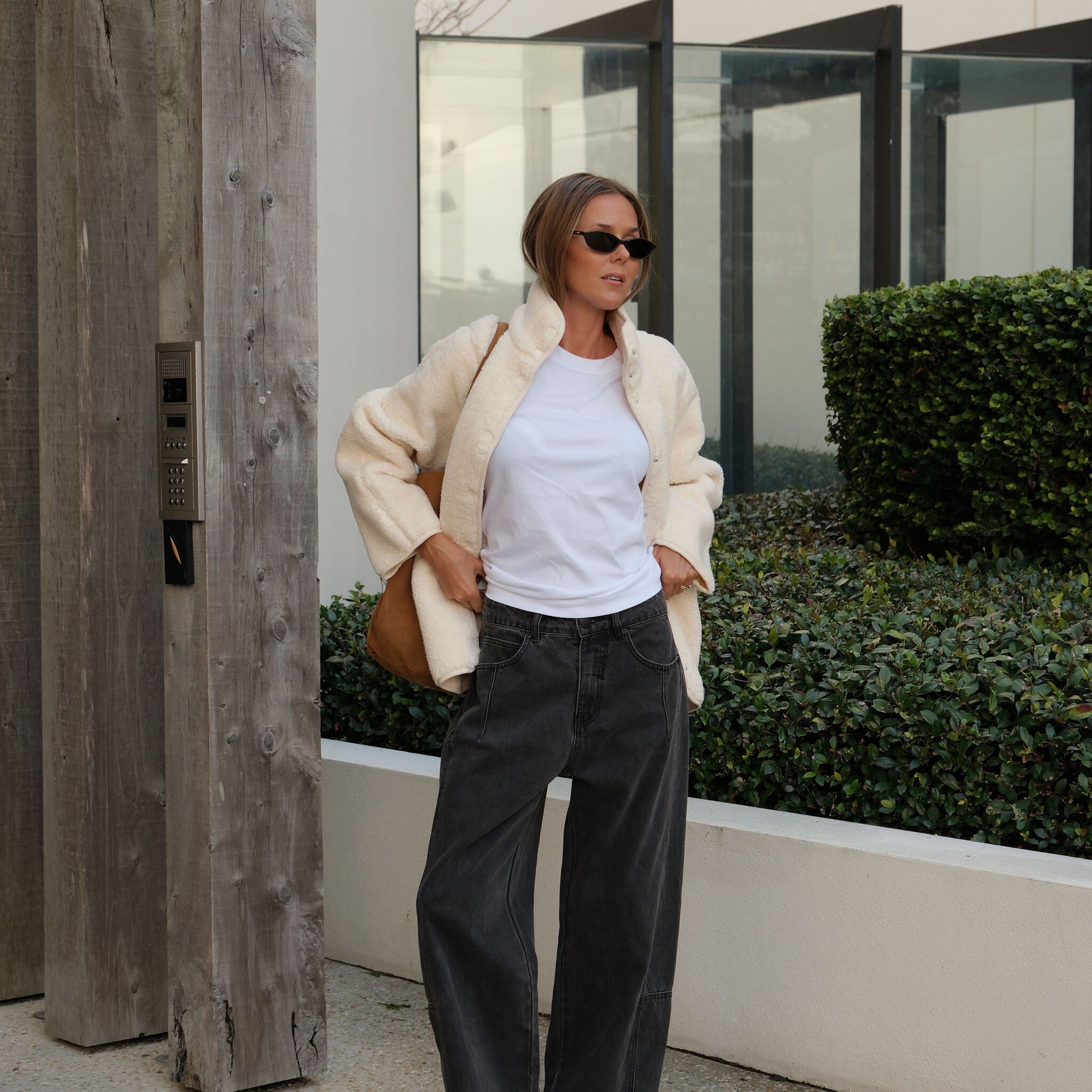 Woman styling marshmallow teddy jacket open over white tee with casual street look