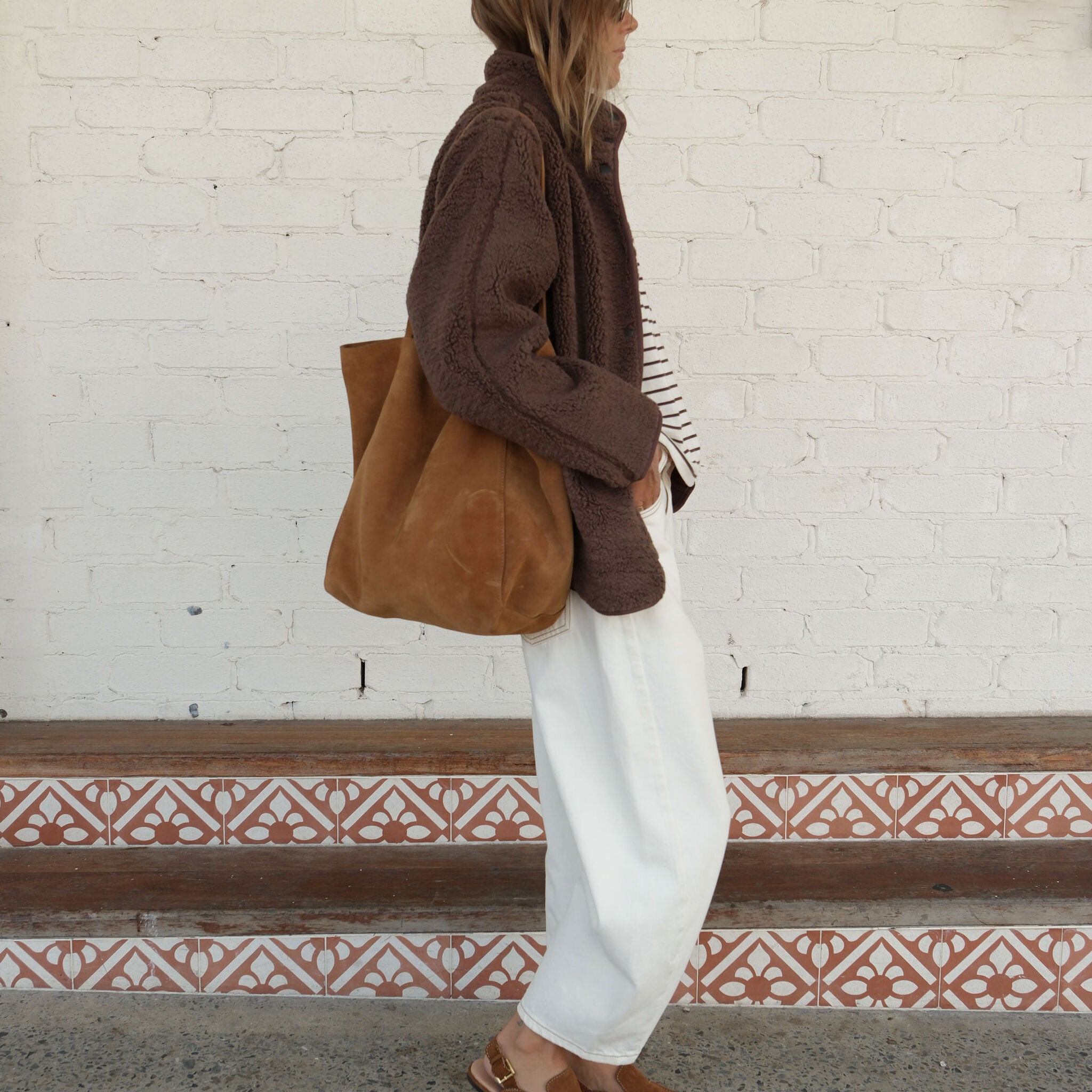 Side profile of chocolate brown teddy jacket highlighting oversized sleeves and cozy sherpa material