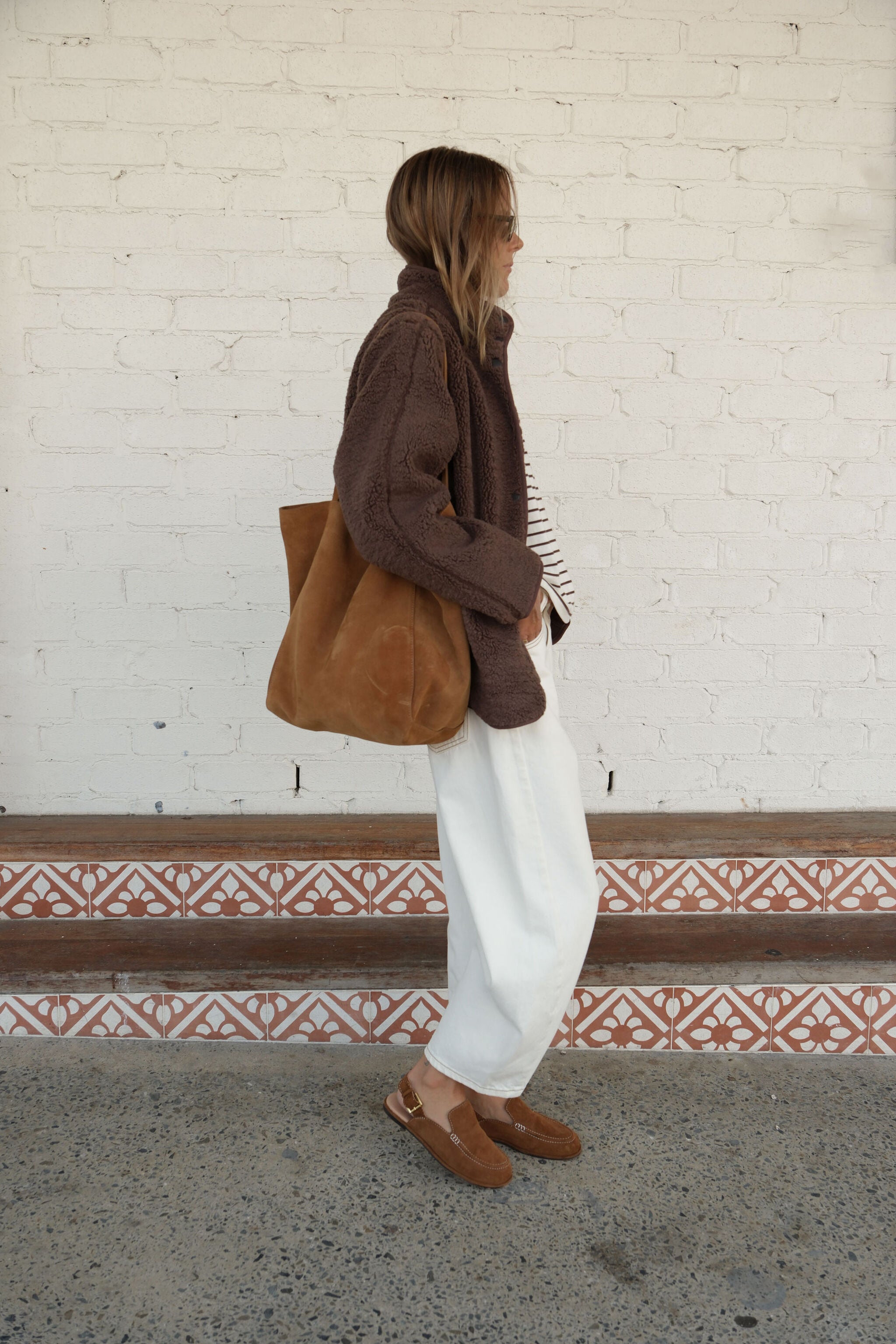 Side profile of chocolate brown teddy jacket highlighting oversized sleeves and cozy sherpa material