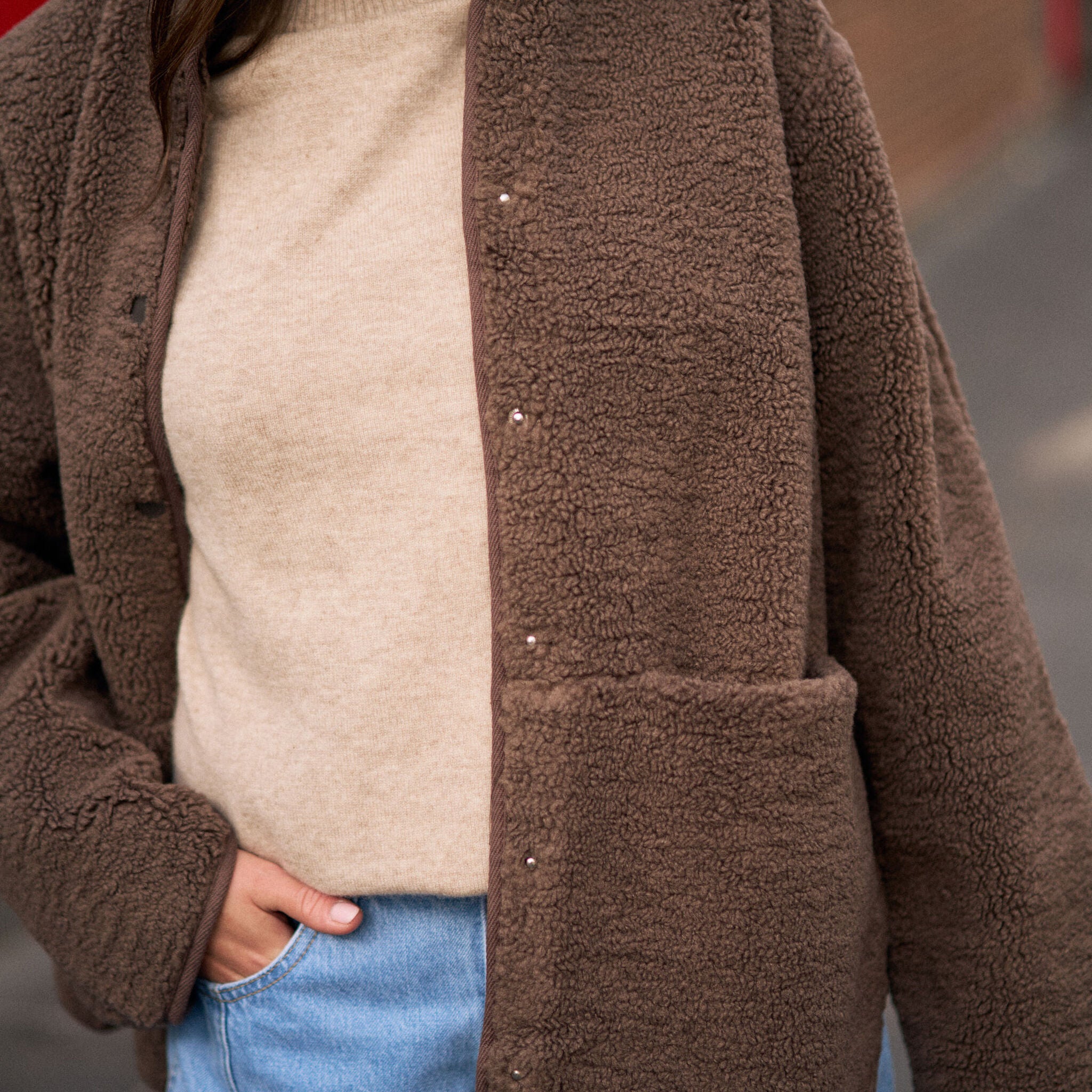 Close-up of chocolate brown teddy jacket showing snap button details and fluffy sherpa fleece texture