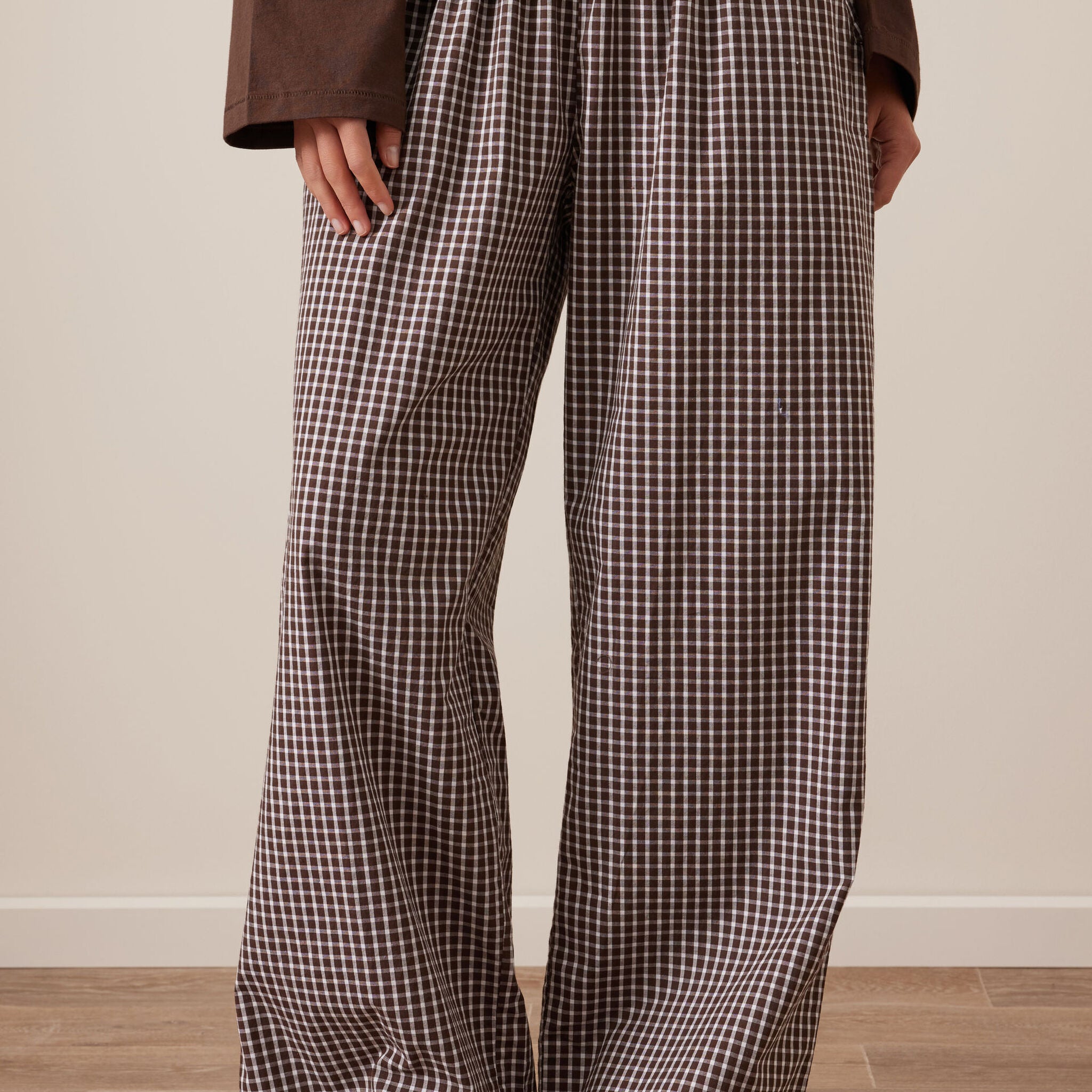 Front view of chocolate check lounge pants on model showing wide leg fit and elastic waist