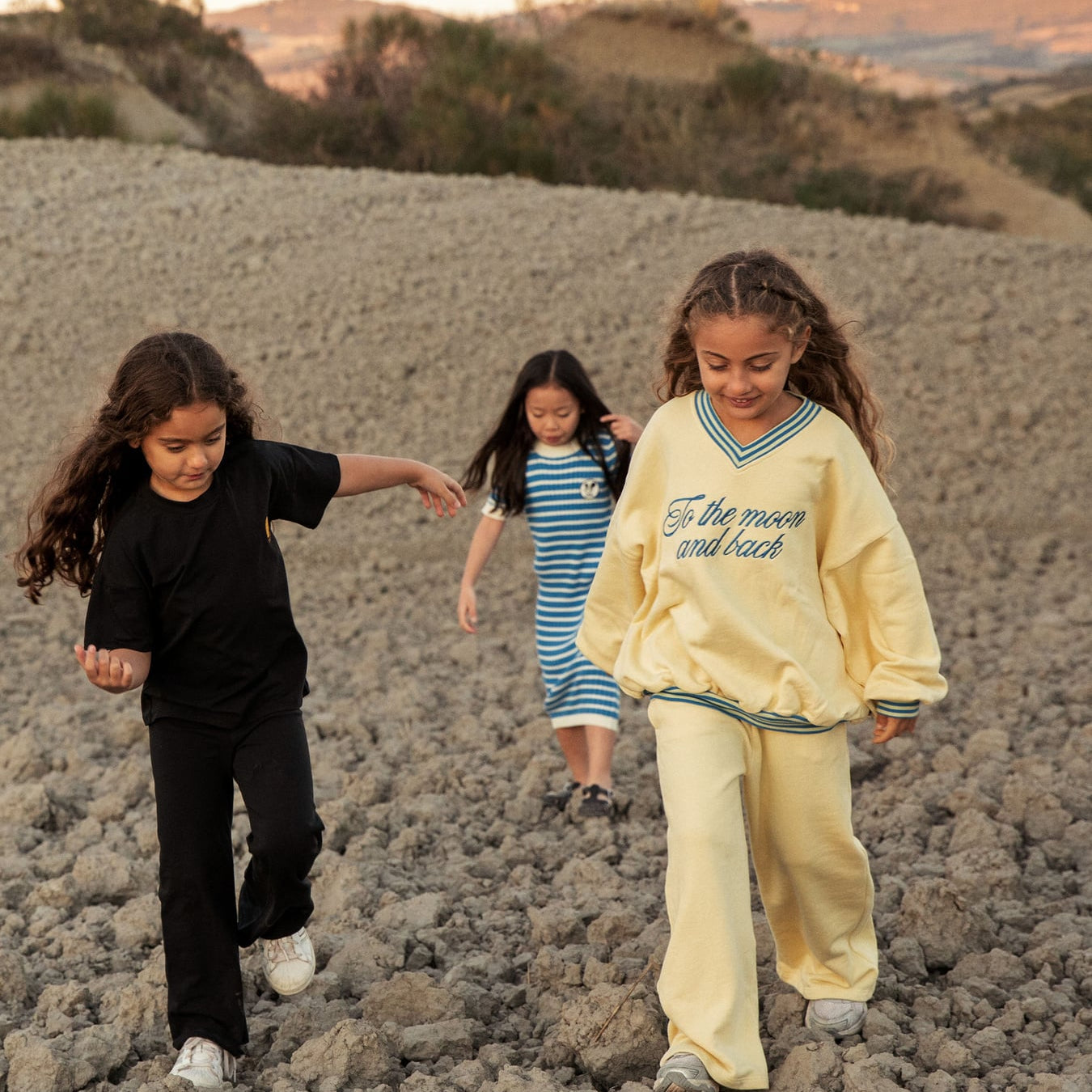 Action shot of children playing while wearing mini rodini To the Moon yellow sweatshirt