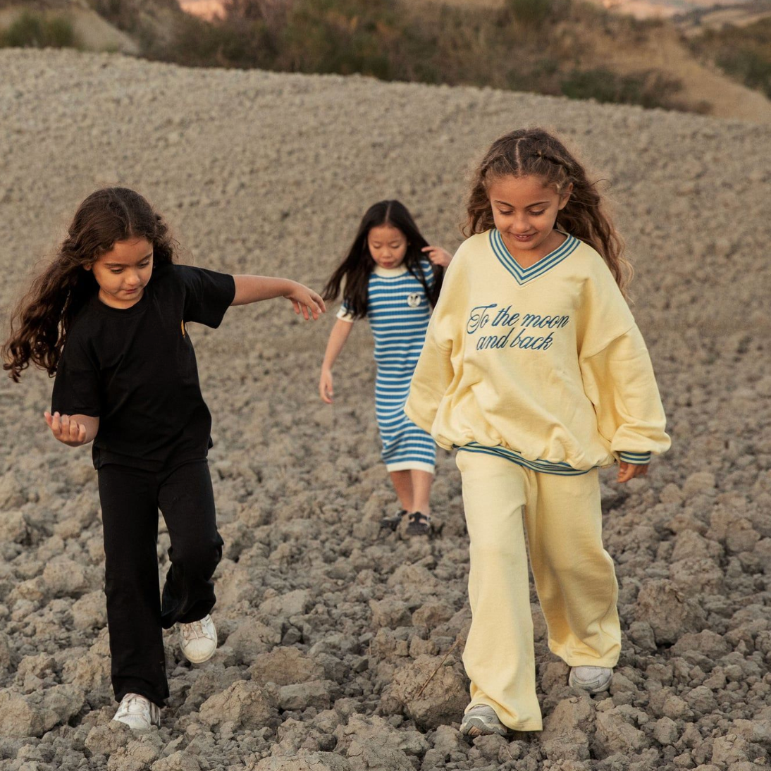 Girl walking in To the moon emb sweatpants - Yellow | Mini Rodini