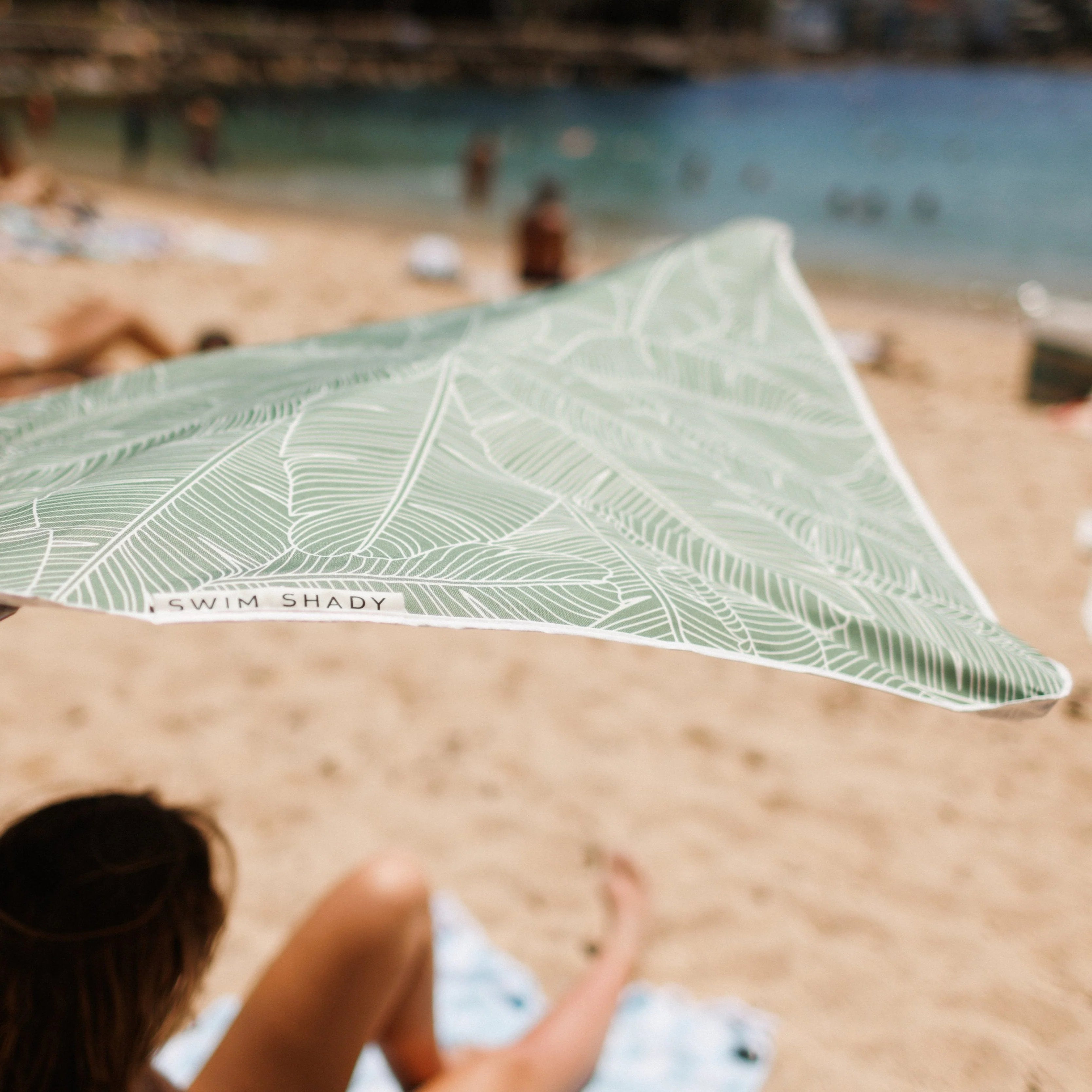 Compact Beach umbrella with leaf pattern on a sandy beach