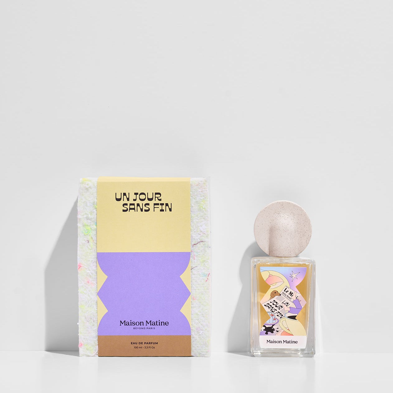 Un Jour Sans Fin perfume bottle and yellow purple packaging box displayed together on white surface