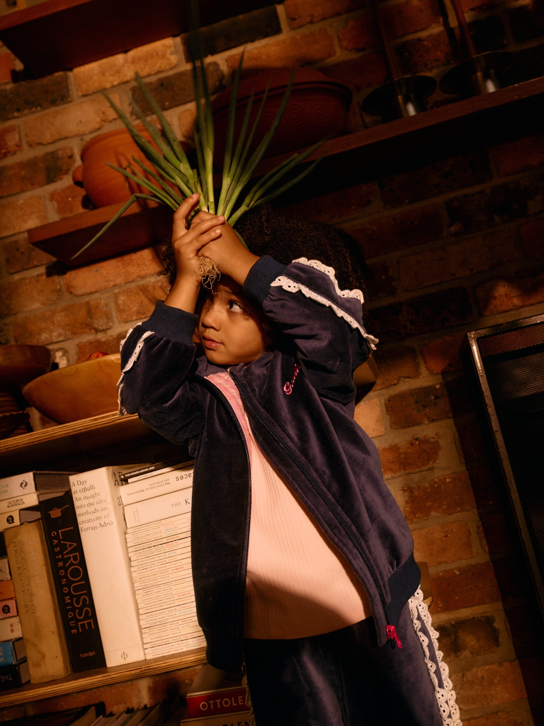 Navy velour sweat jacket with white broderie trim detail shown open over pink top