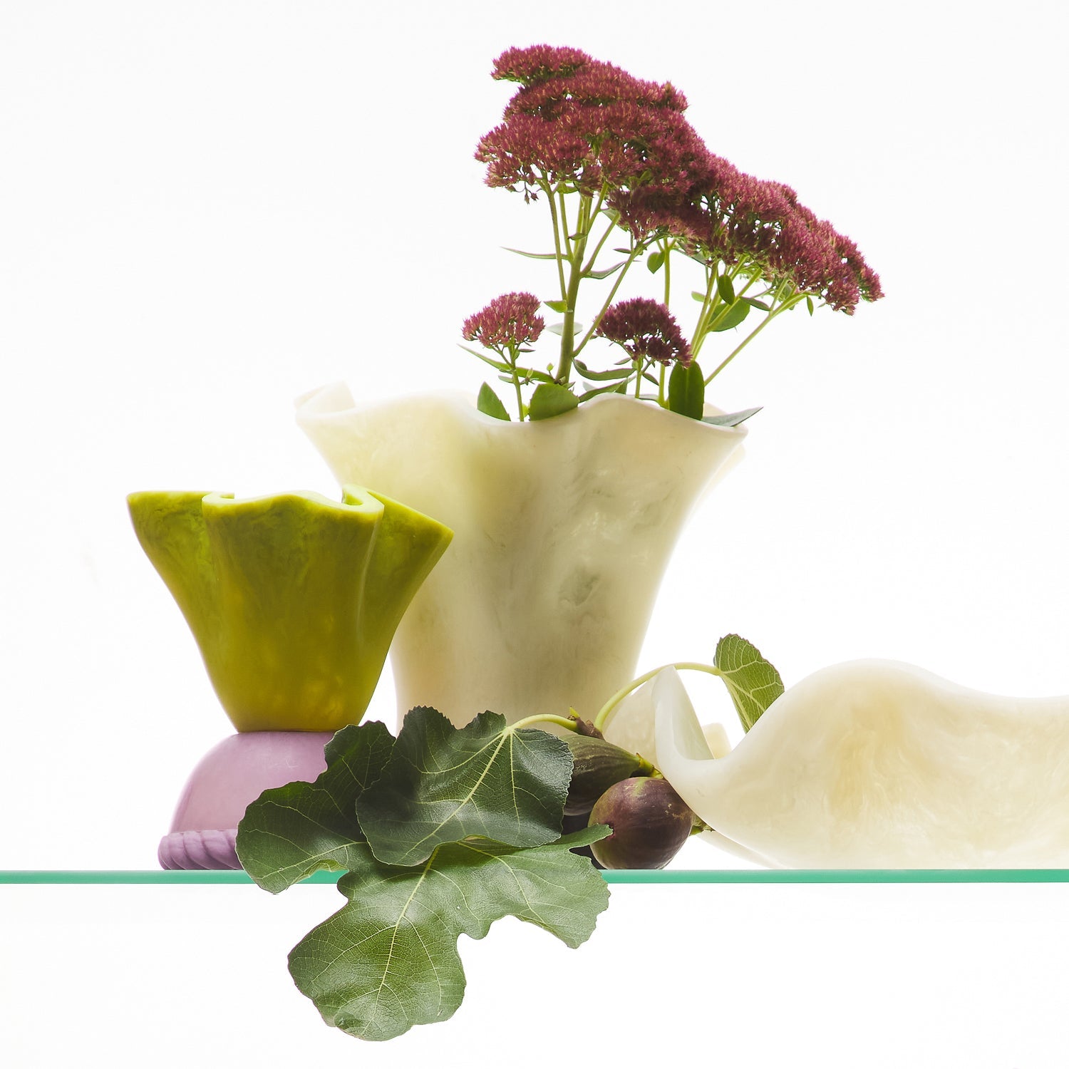 Pearl Violetta Vase styled on a glass shelf holding wildflowers, shown with other sculptural ceramic pieces