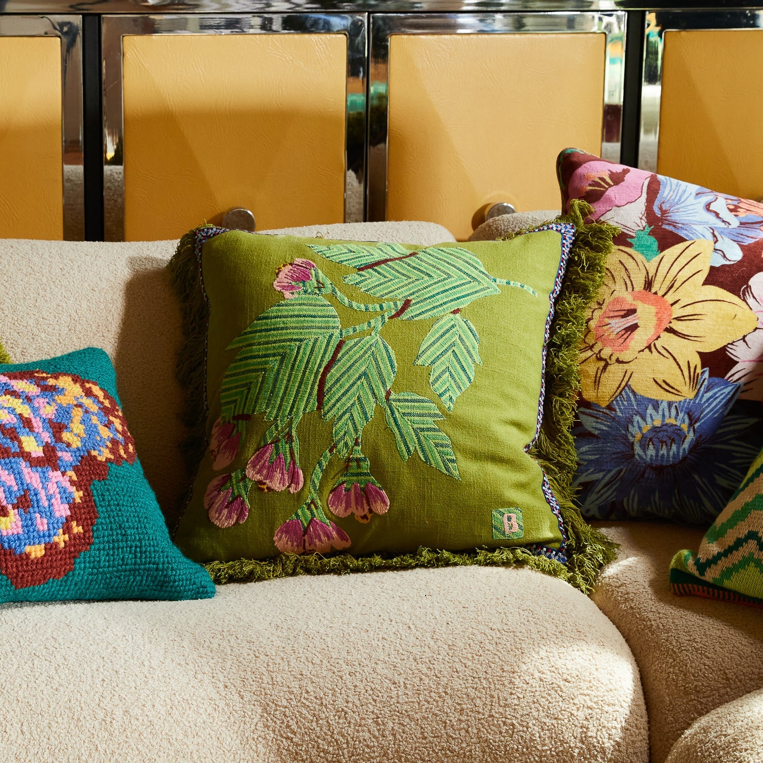 Front view of Vivi Applique Cushion in juniper green with tropical palm leaves and pink flower embroidery