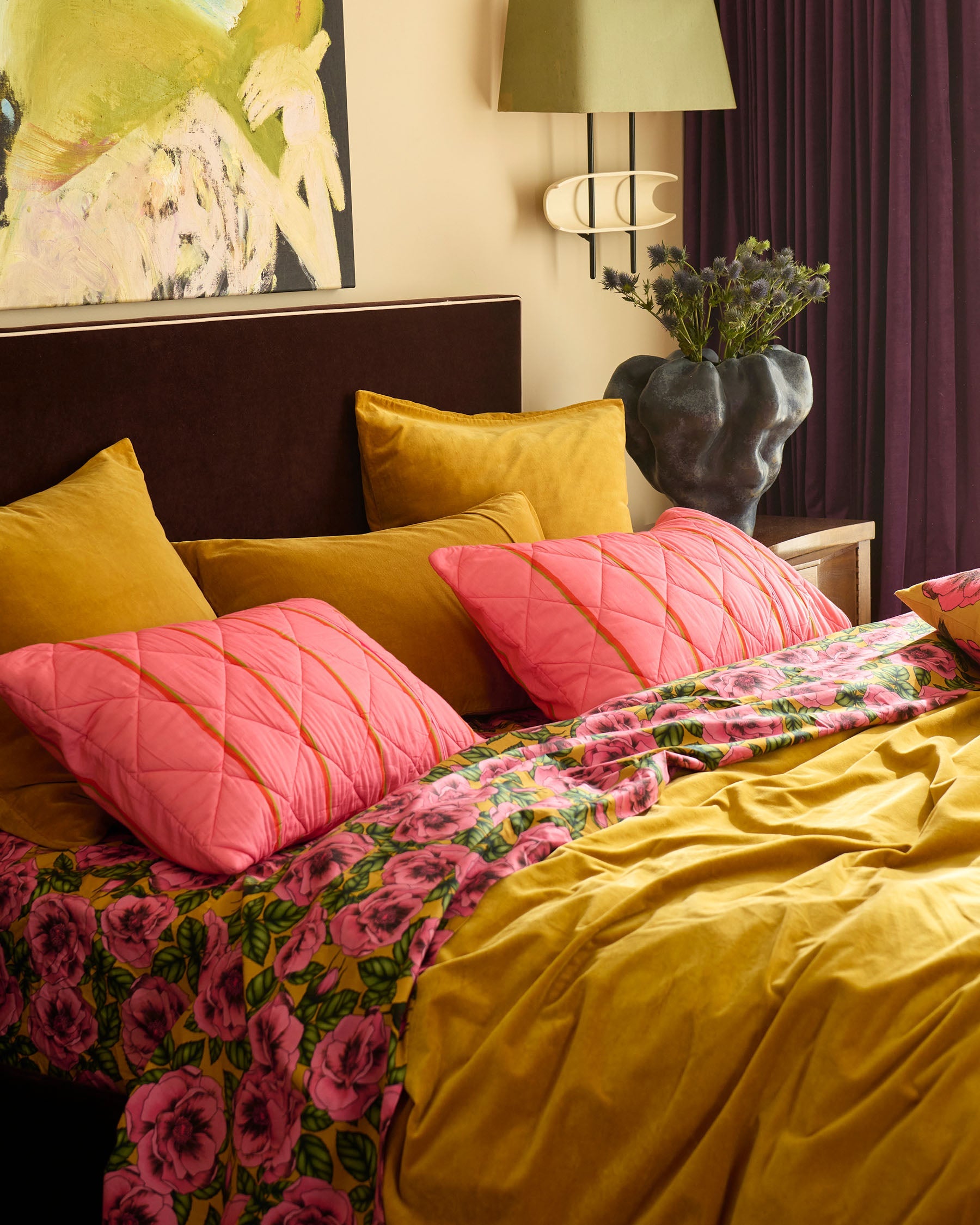 Wategos Soiree Stripe pink quilted pillowcases with orange stripes on bed with yellow velvet cushions