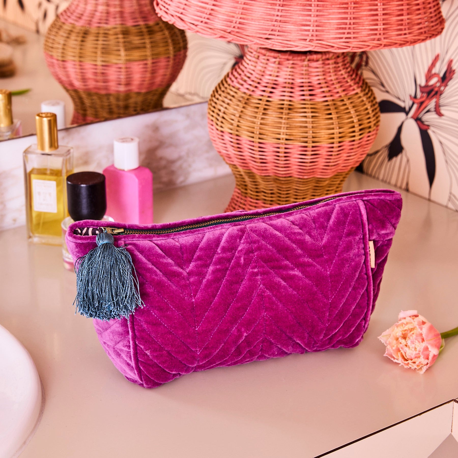 Kip Co Wild Grape toiletry bag styled with beauty products and wicker baskets in boho setting