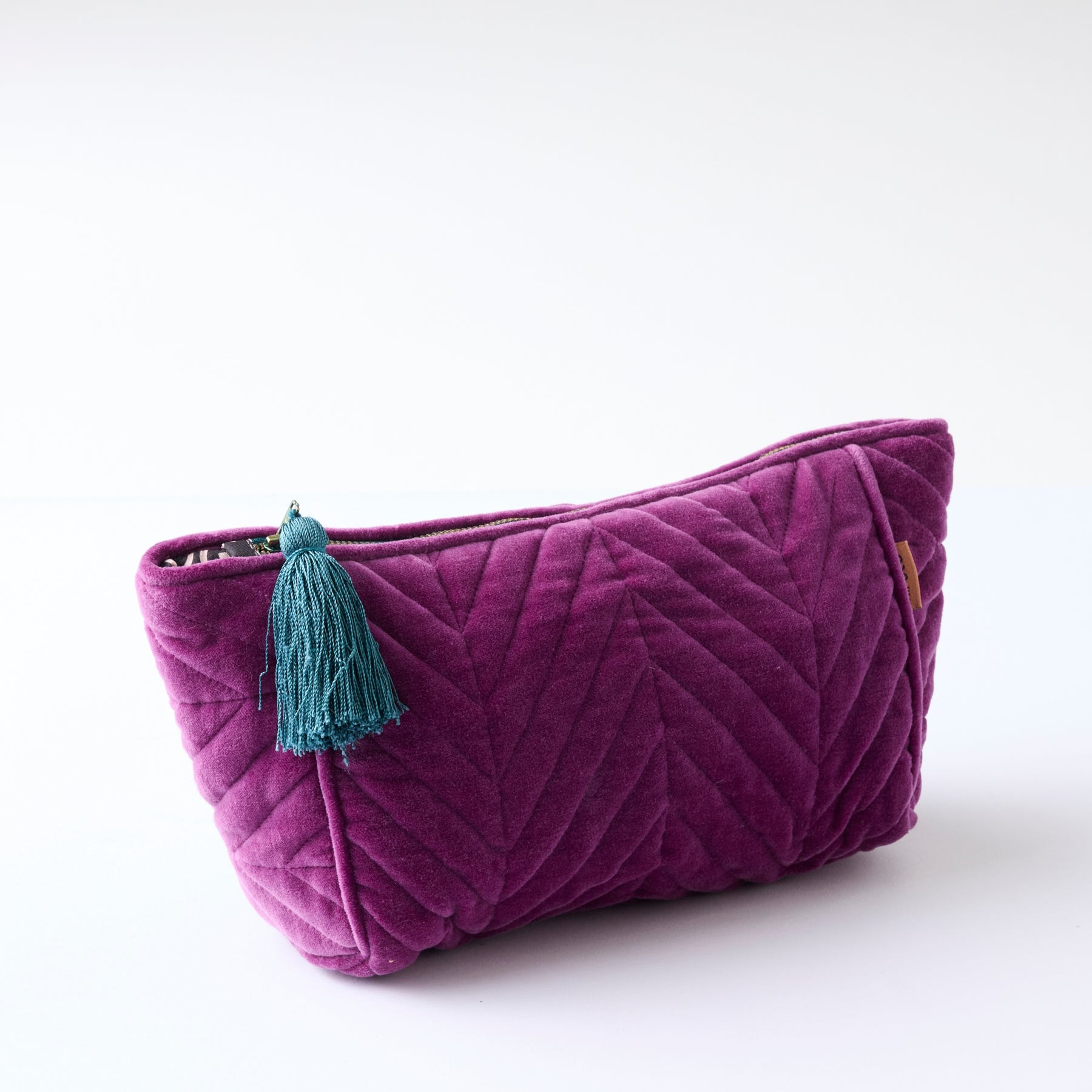 Wild Grape Velvet Toiletry Bag by Kip Co isolated view showing quilted pattern and tassel charm