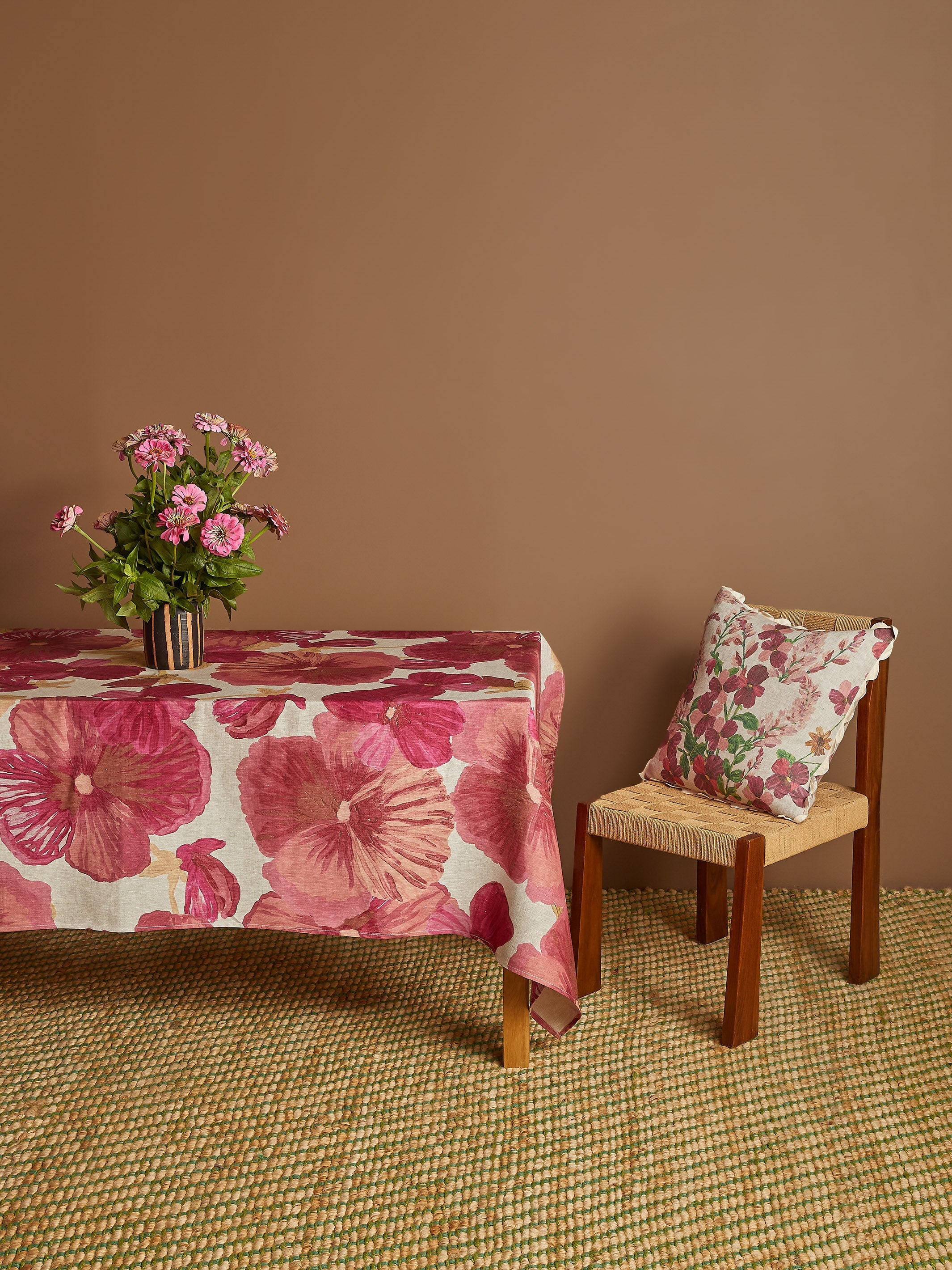 Side view of Wild Pansy Pink Tablecloth draped over table edge showing full pattern coverage